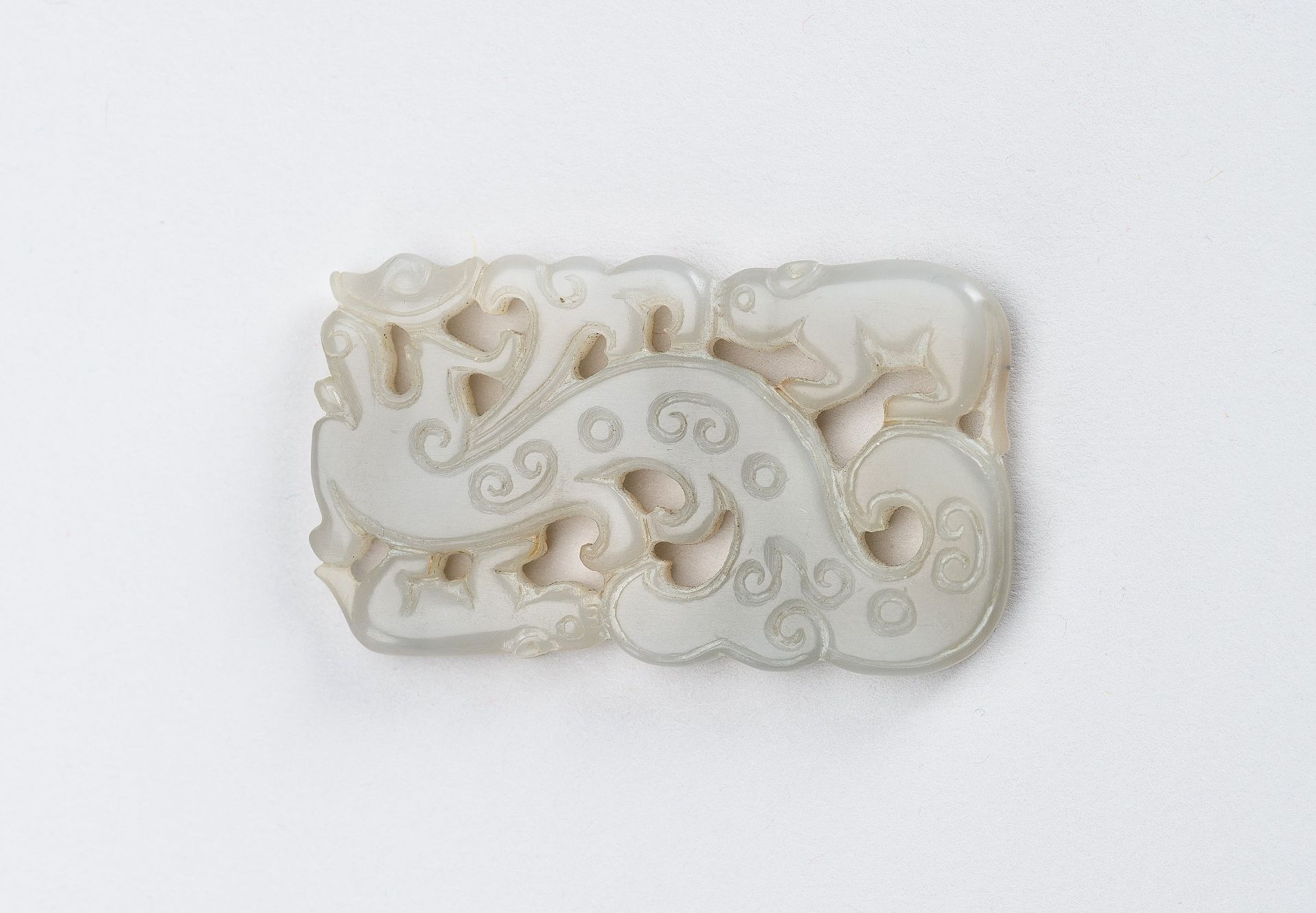 A CELADON-WHITE JADE 'DRAGON AND TAPIR' PENDANT, QING DYNASTY