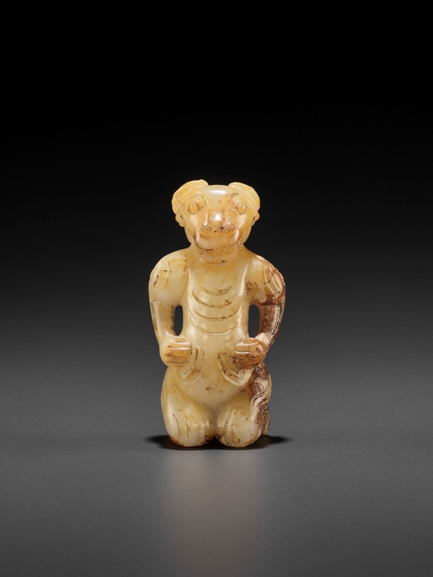 A YELLOW AND RUSSET JADE FIGURE WITH A RAM'S HEAD