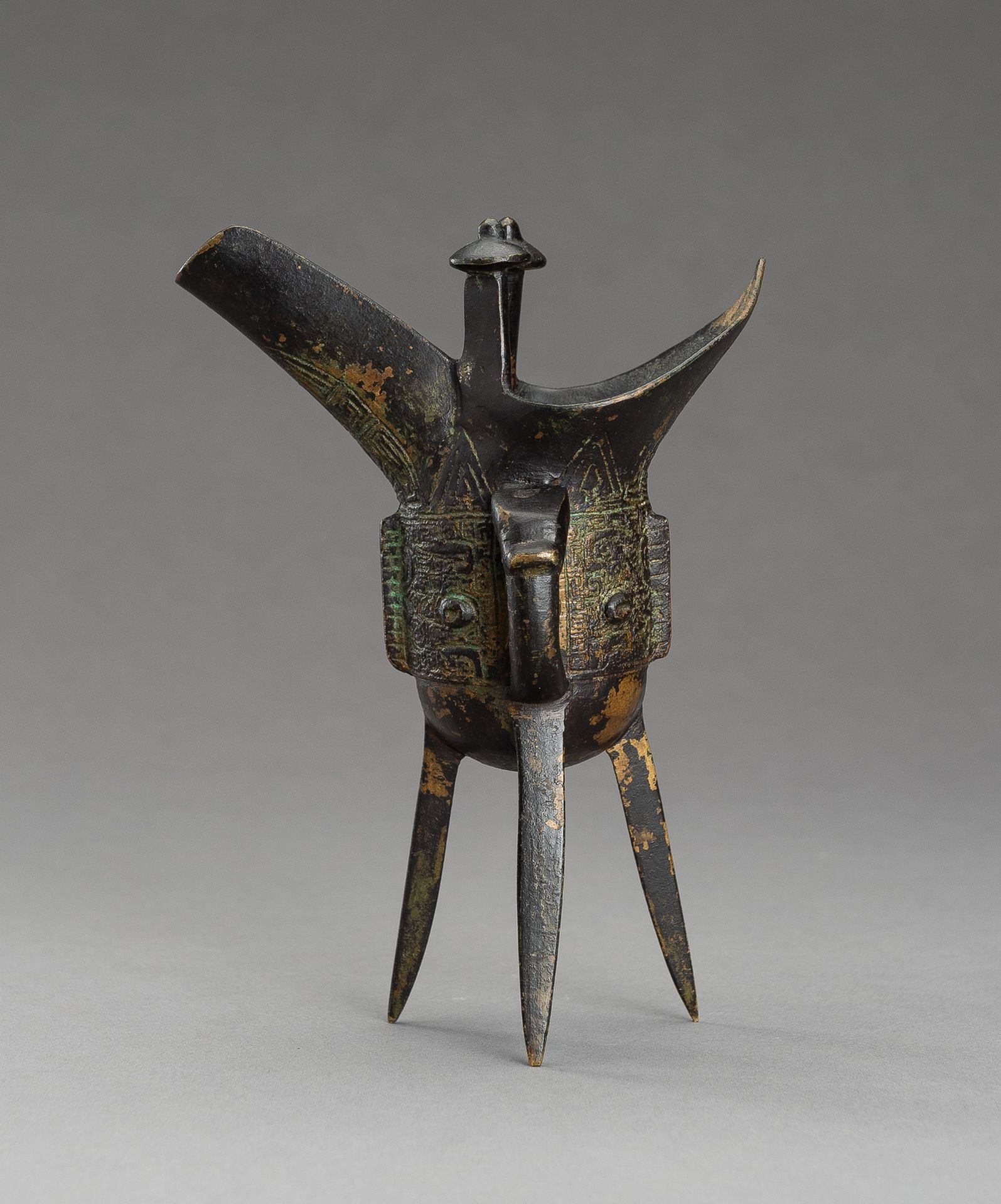 AN ARCHAISTIC SHANG STYLE BRONZE RITUAL TRIPOD WINE VESSEL, JUE