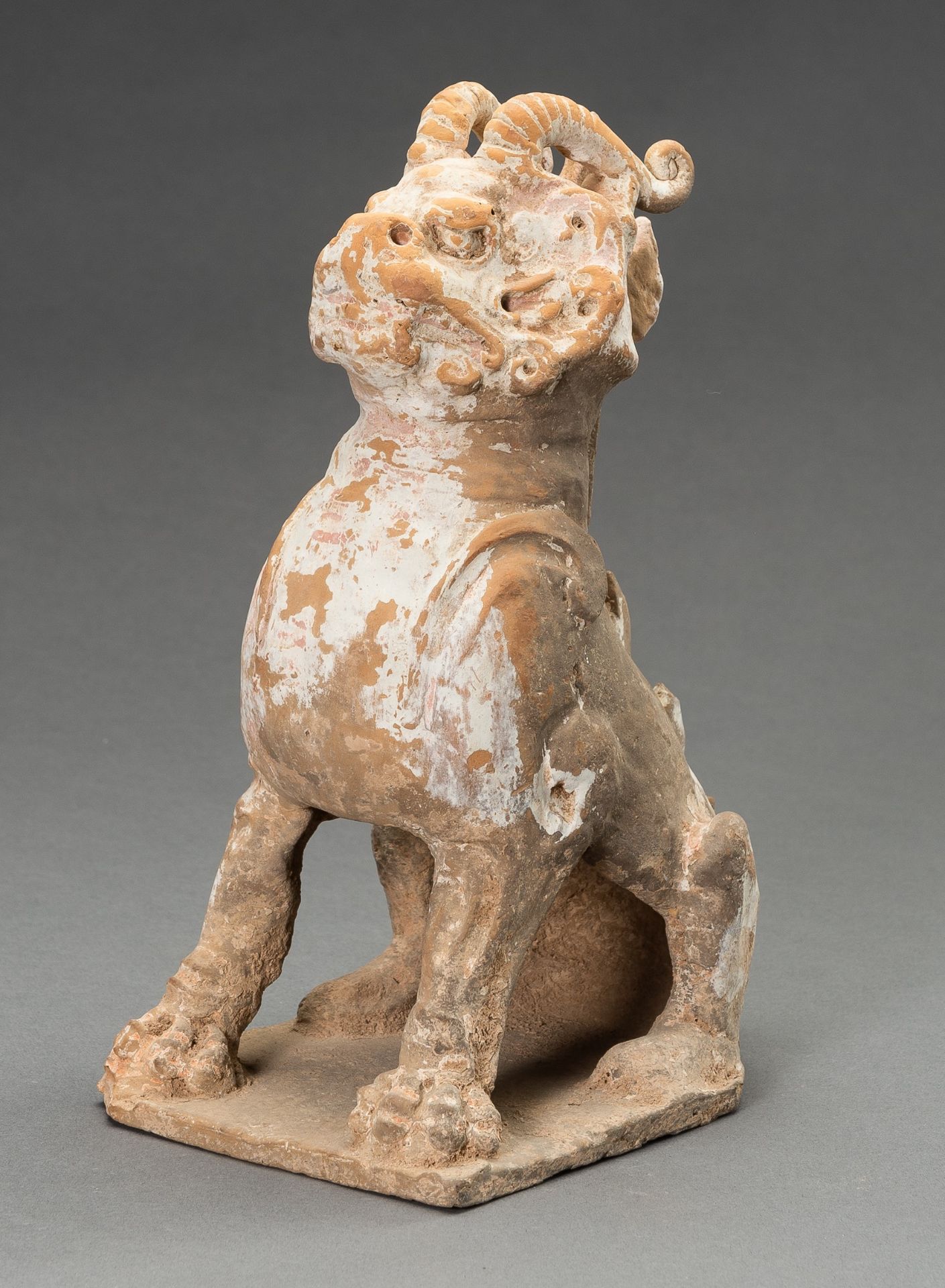 A POTTERY FIGURE OF A HORNED GUARDIAN BEAST, TANG DYNASTY OR EARLIER