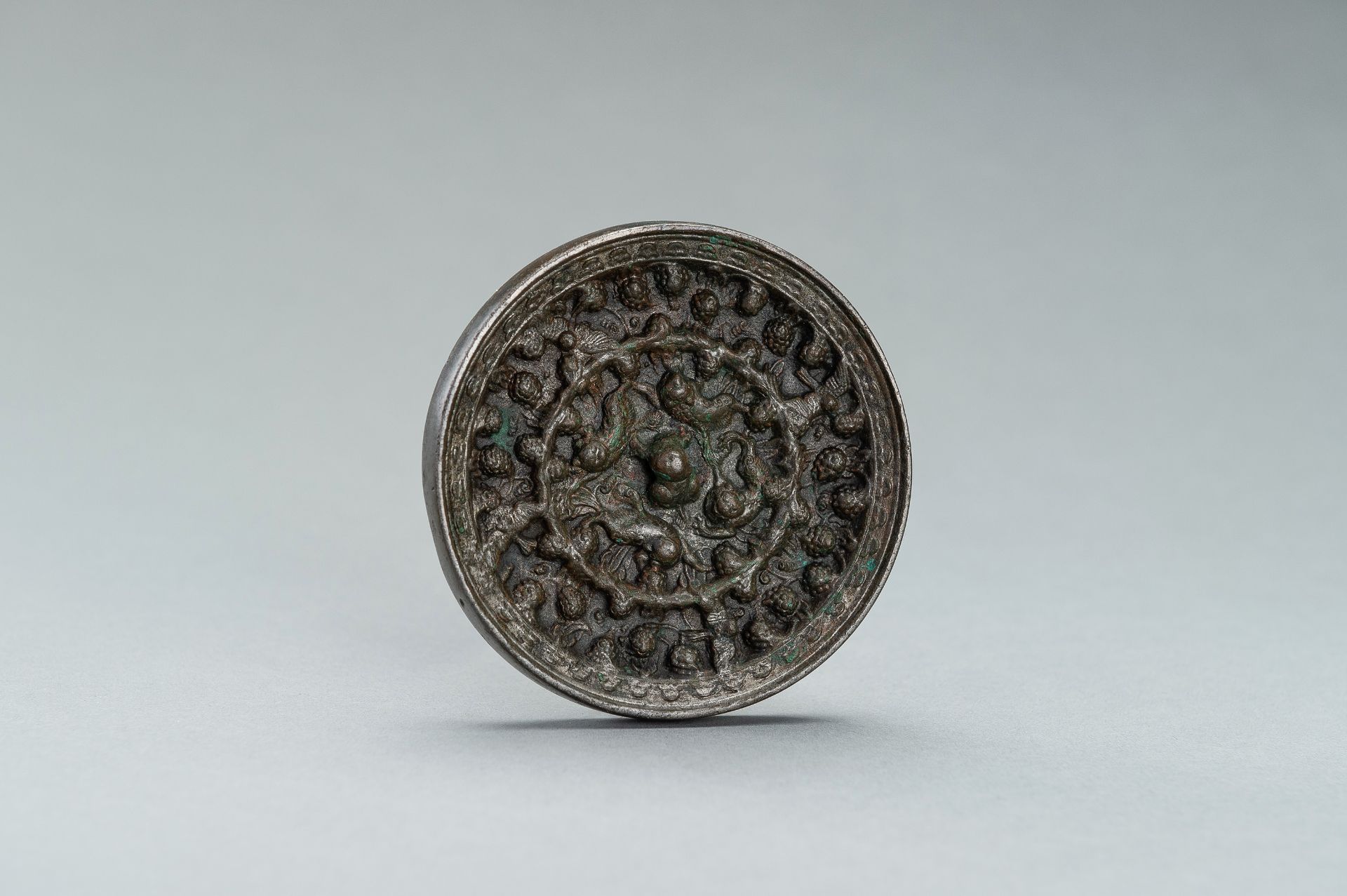 A SILVERY TANG DYNASTY BRONZE 'LION AND GRAPEVINE' MIRROR - Image 6 of 9