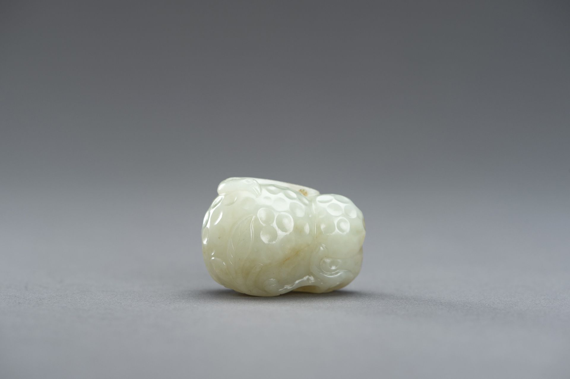 A CELADON JADE PENDANT OF A LYCHEE WITH BIRDS, 1920s - Image 7 of 9