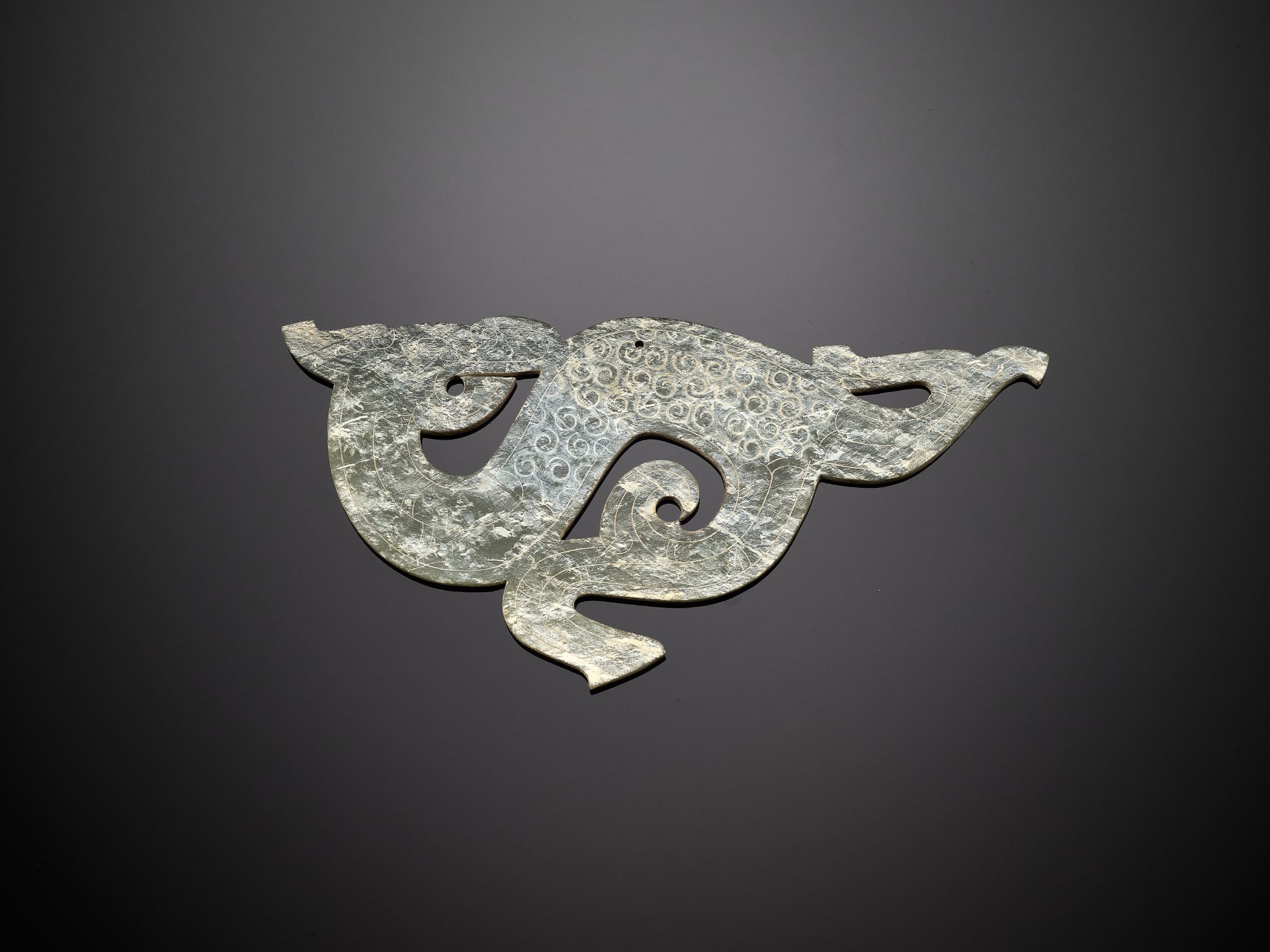 A PALE GREEN JADE 'DRAGON' PENDANT, WARRING STATES