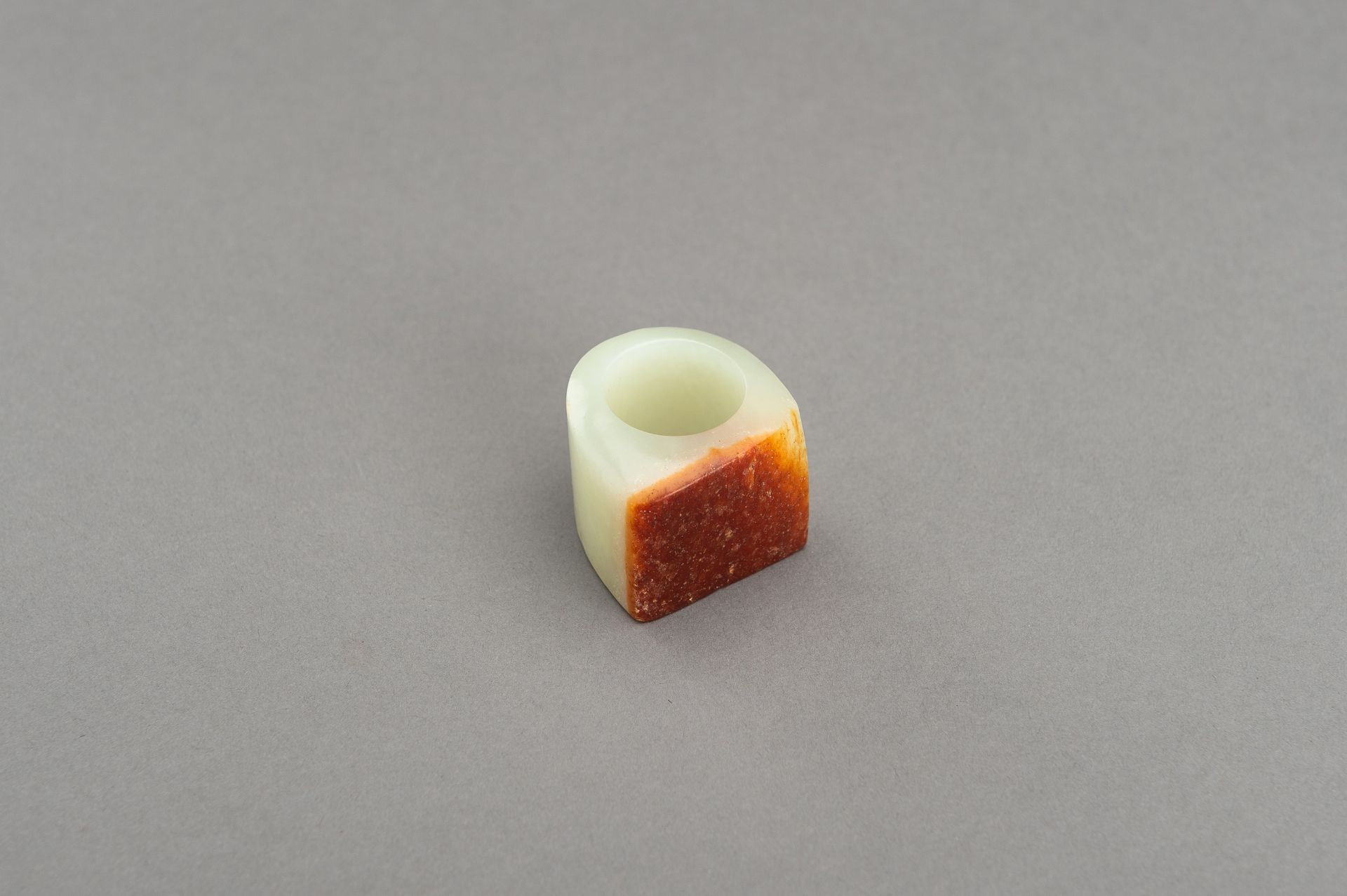 A PALE CELADON AND RUSSET JADE ARCHER'S RING - Image 7 of 8