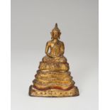 A SMALL LACQUER GILT BRONZE FIGURE OF A SEATED BUDDHA