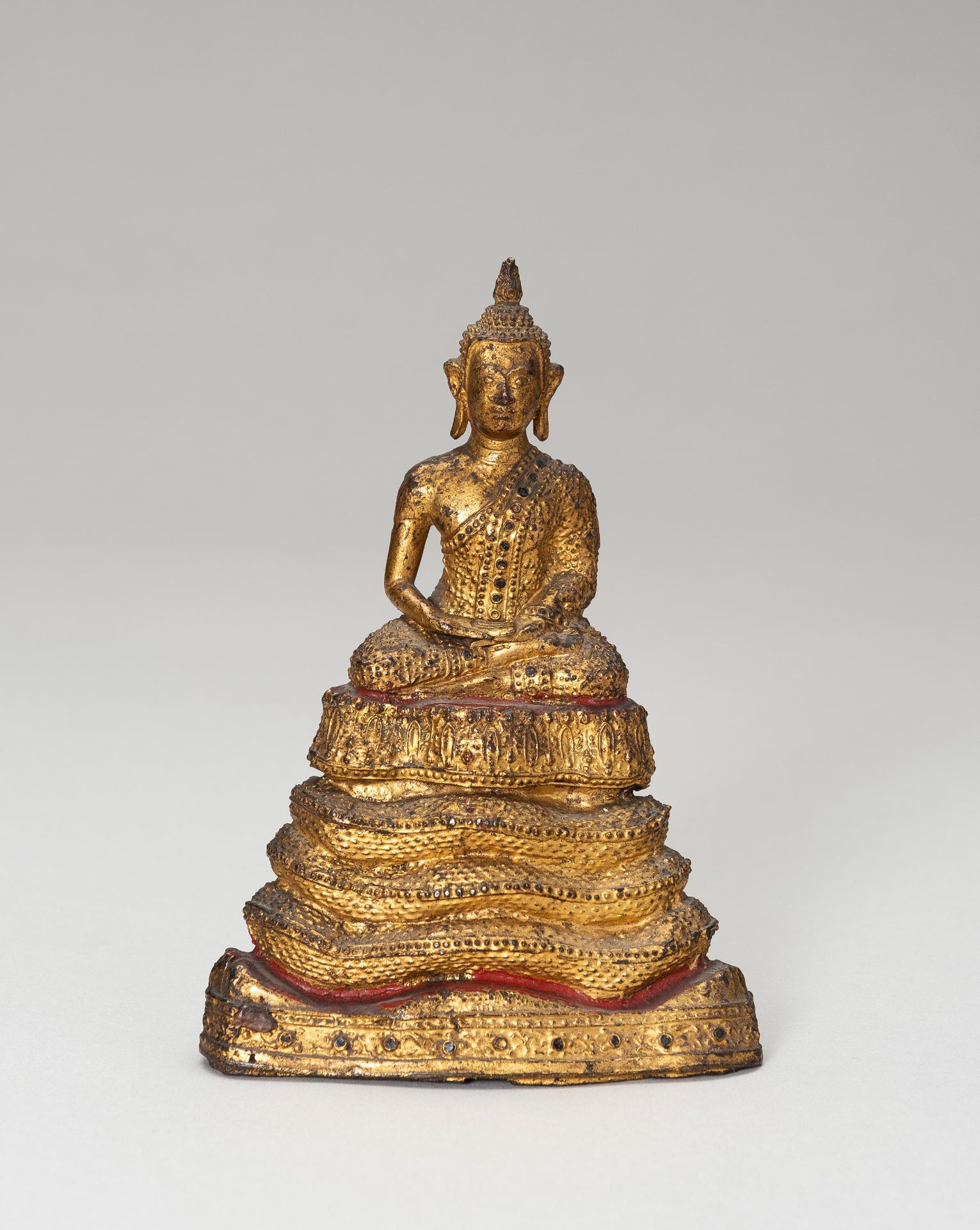 A SMALL LACQUER GILT BRONZE FIGURE OF A SEATED BUDDHA