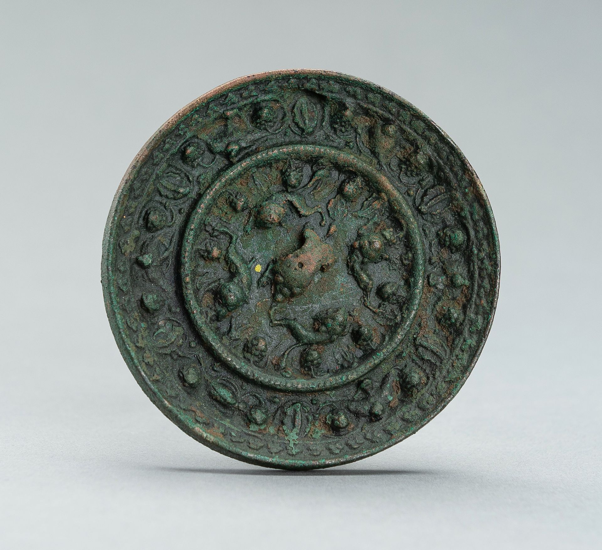 A TANG DYNASTY BRONZE 'LION AND GRAPEVINE' MIRROR