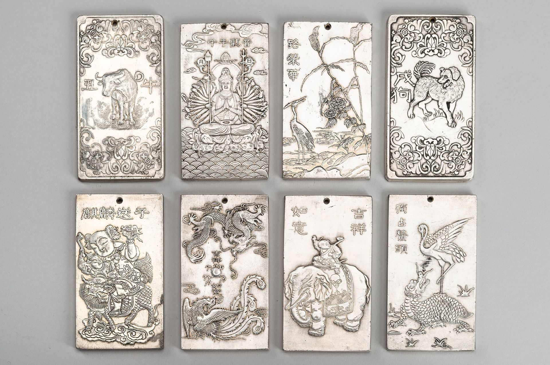 A GROUP OF EIGHT CHINESE 'TIBETAN SILVER' BULLION AMULETS
