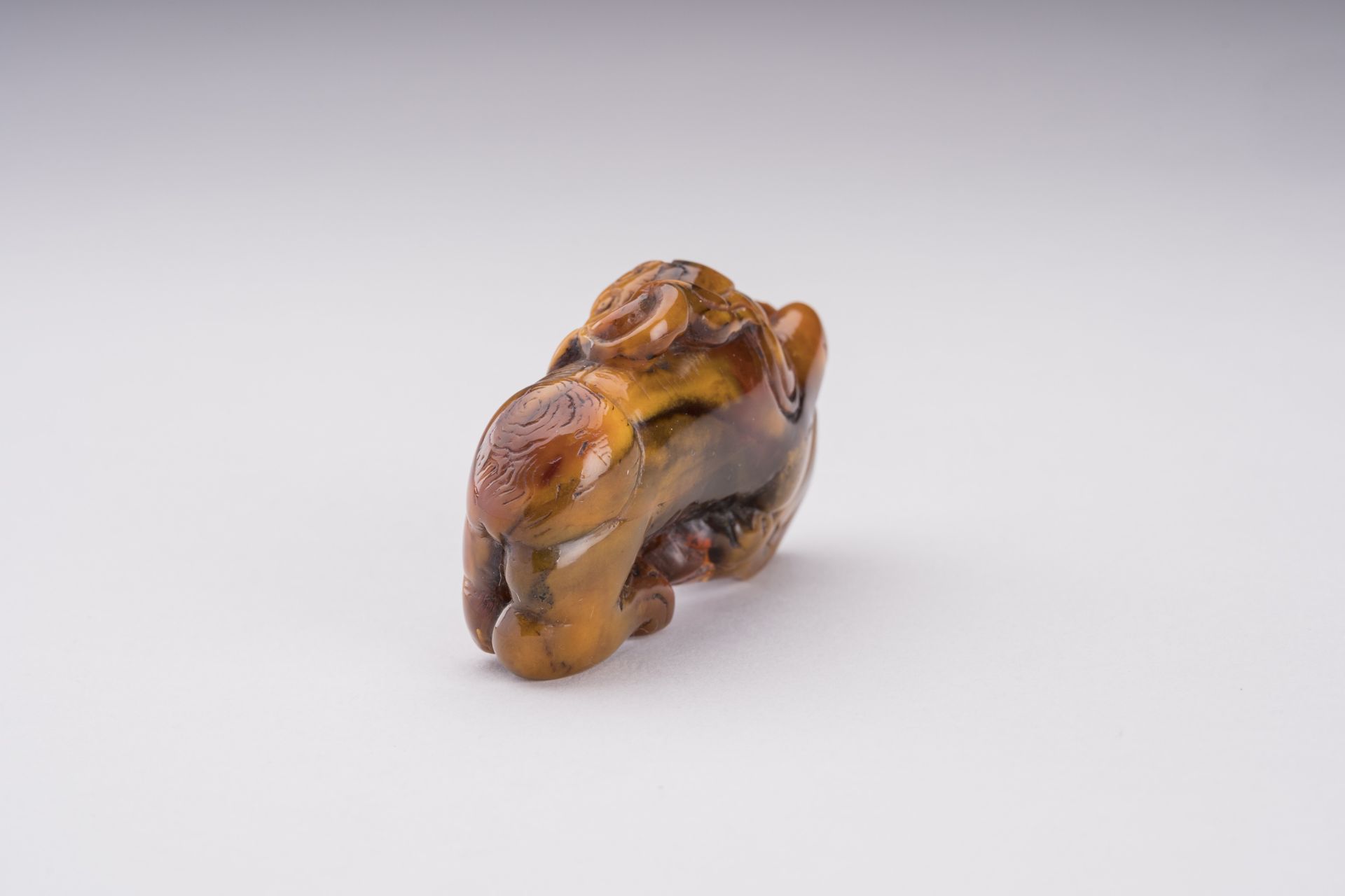 A RARE AMBER CARVING OF A BUDDHIST LION WITH BALL - Bild 5 aus 6