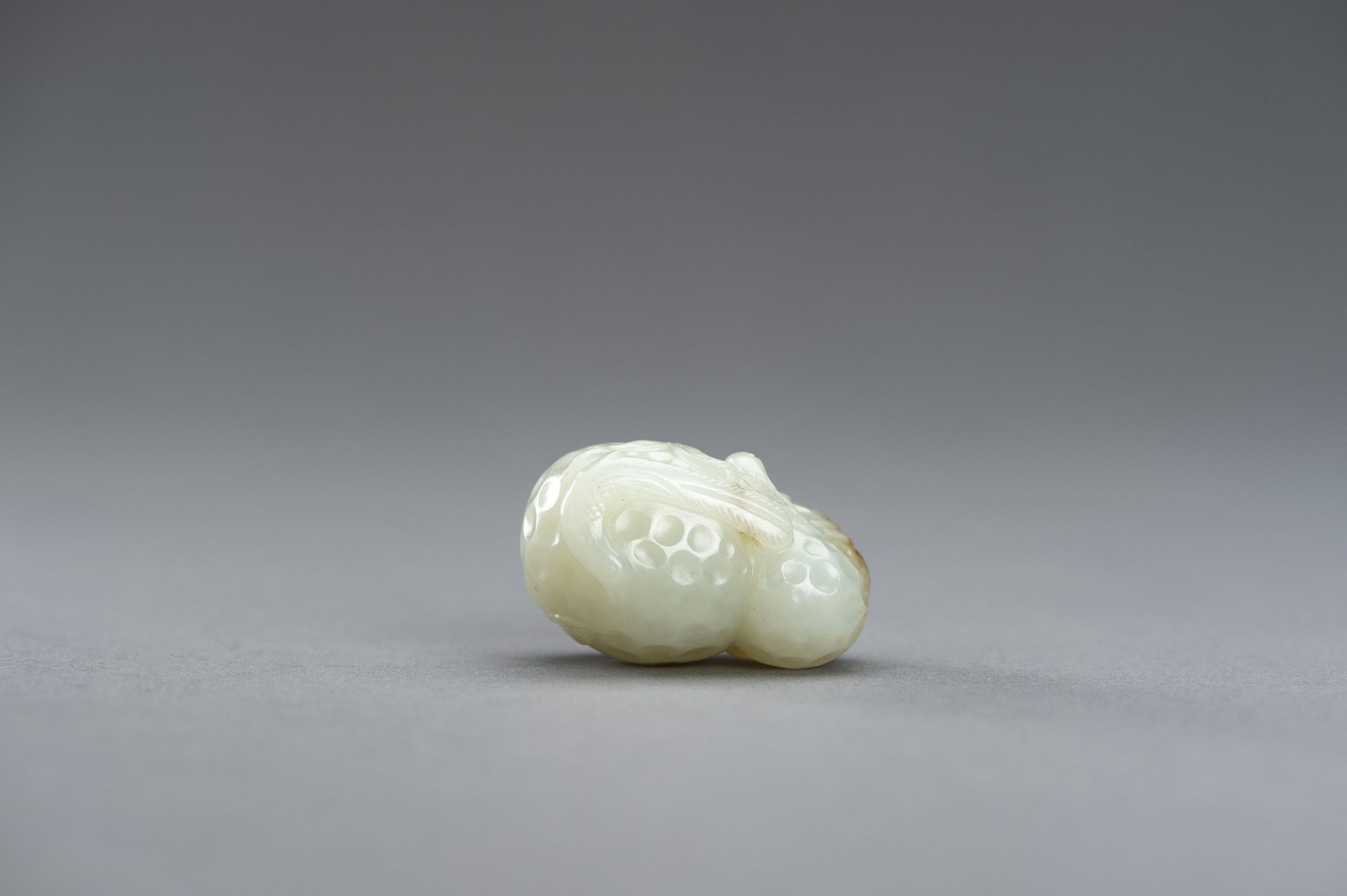 A CELADON JADE PENDANT OF A LYCHEE WITH BIRDS, 1920s - Image 6 of 9