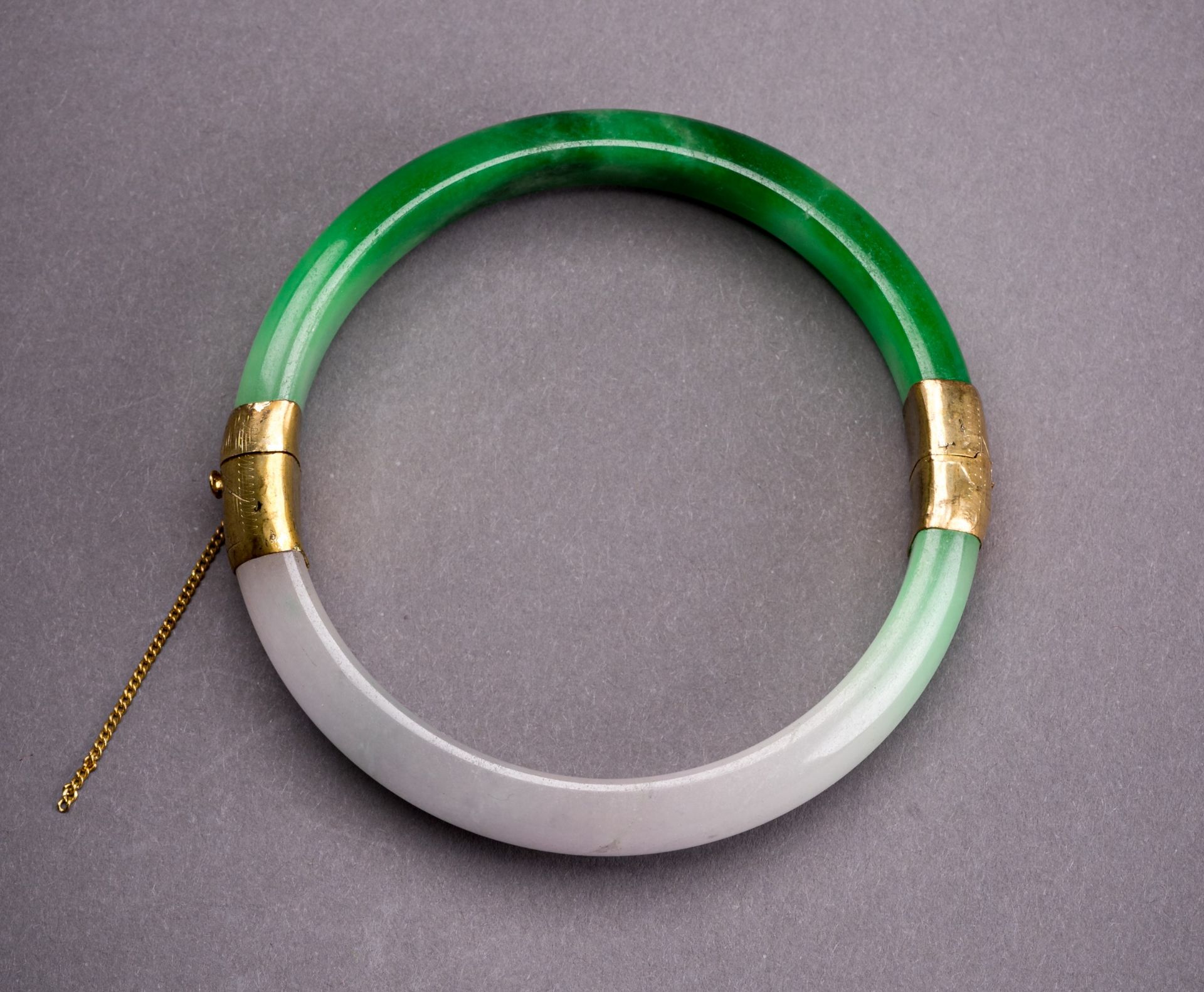 A PALE LAVENDER AND EMERALD GREEN JADEITE BANGLE