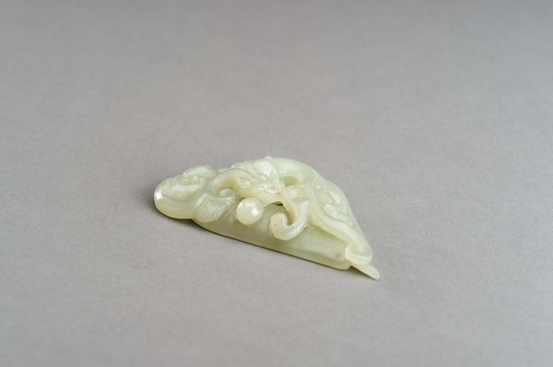 AN ARCHAISTIC PALE CELADON JADE PENDANT OF A CHILONG, 1920s - Image 4 of 14