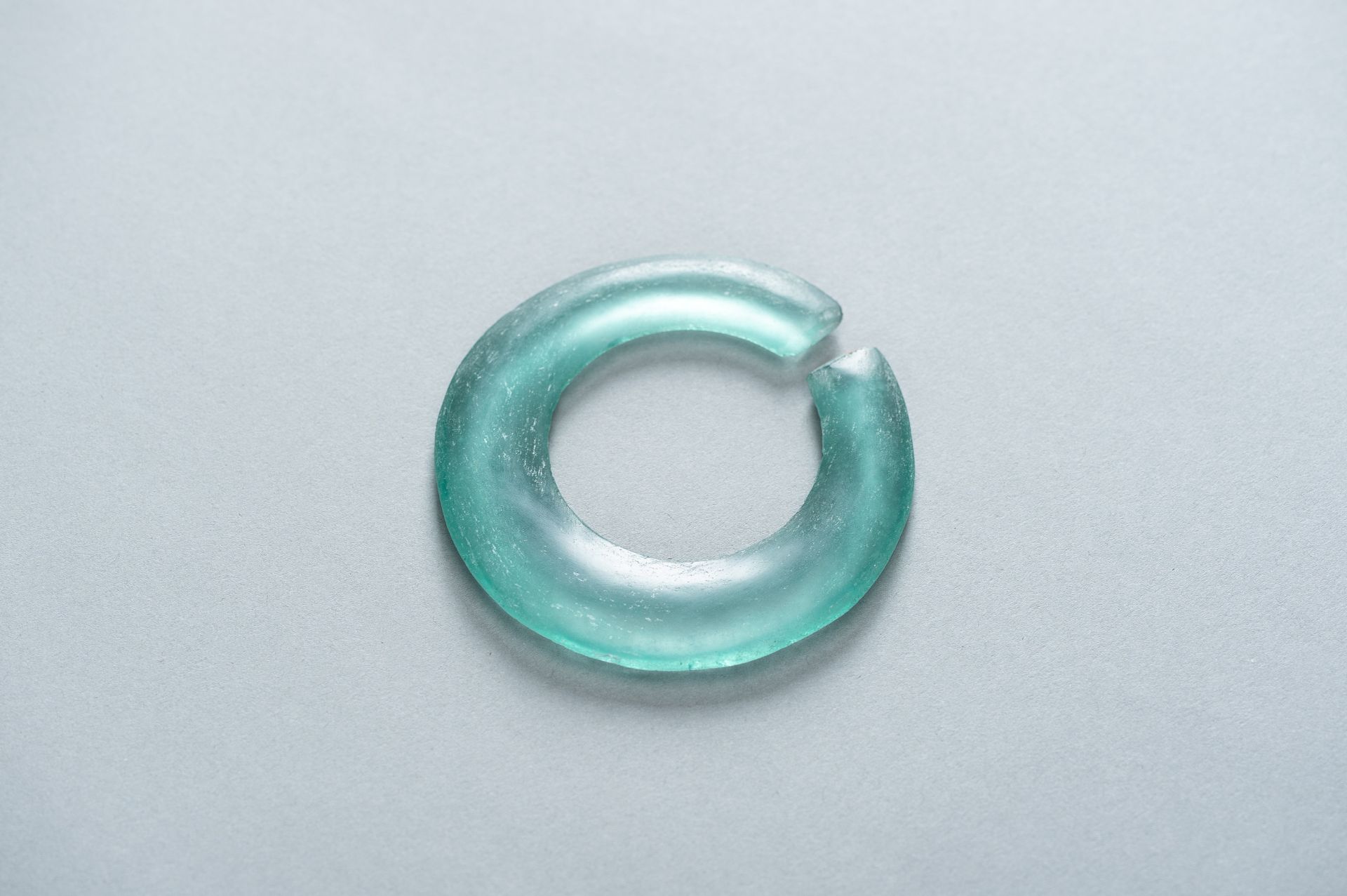 AN ARCHAIC PALE GREEN GLASS DISC - Image 8 of 9