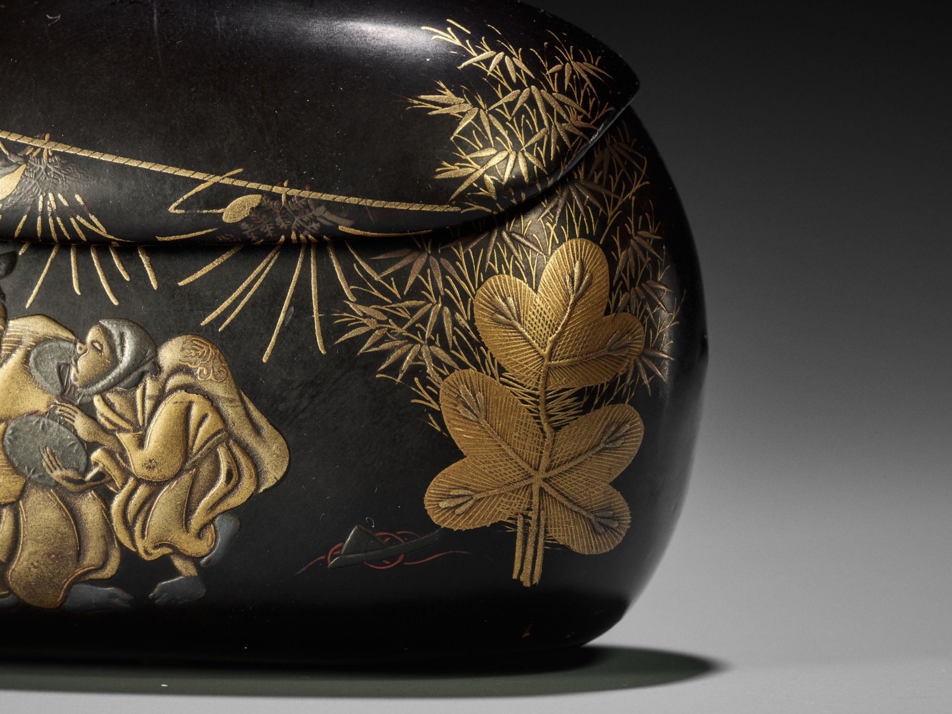 A RARE BLACK AND GOLD LACQUER TONKOTSU DEPICTING A NEW YEAR'S SCENE - Image 3 of 7