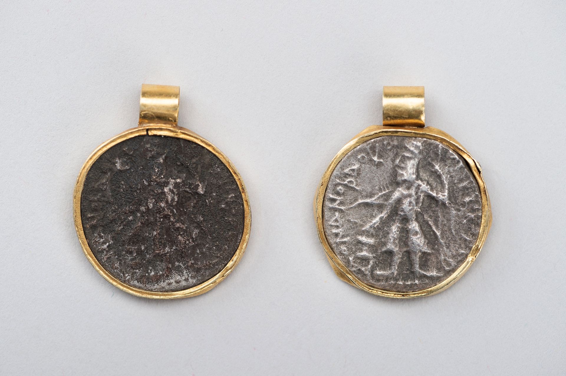 A PAIR OF 'KANISHKA SILVER COIN' PENDANTS