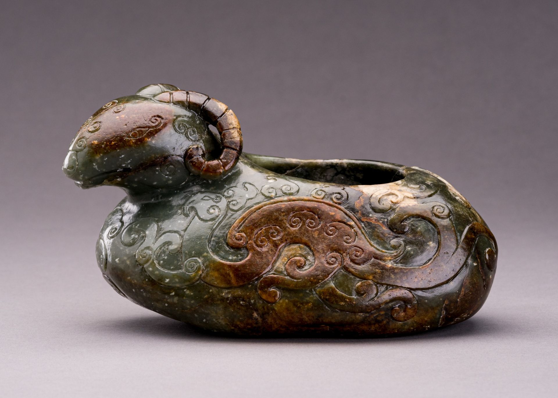 AN ARCHAISTIC SPINACH GREEN AND RUSSET JADE 'RAM' VESSEL