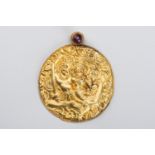 A GOLD REPOUSSE PENDANT WITH SHIVA AND PARVATI