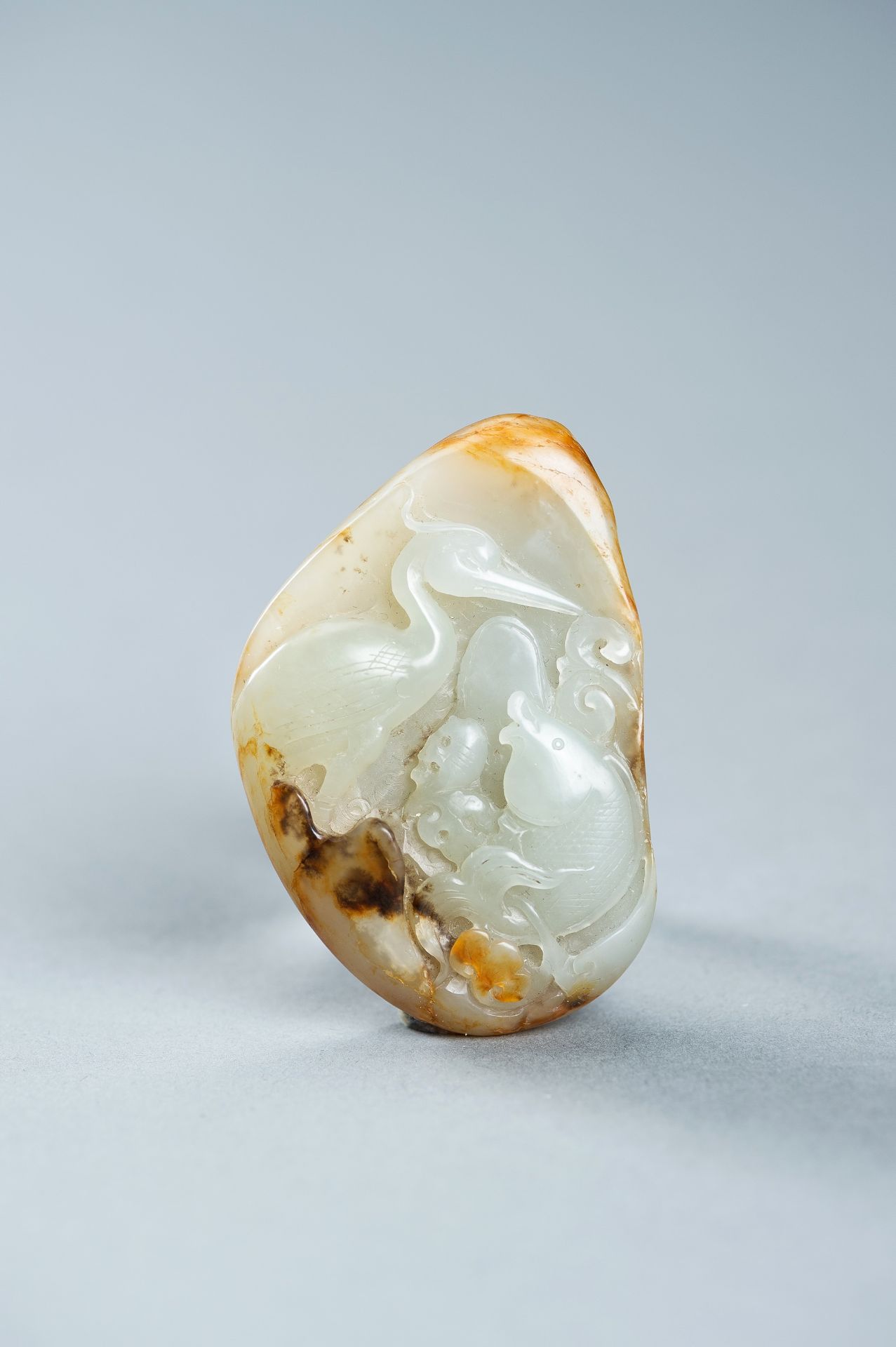 A CELADON AND RUSSET JADE 'FISH AND CRANE' PENDANT, c. 1920s - Image 8 of 9