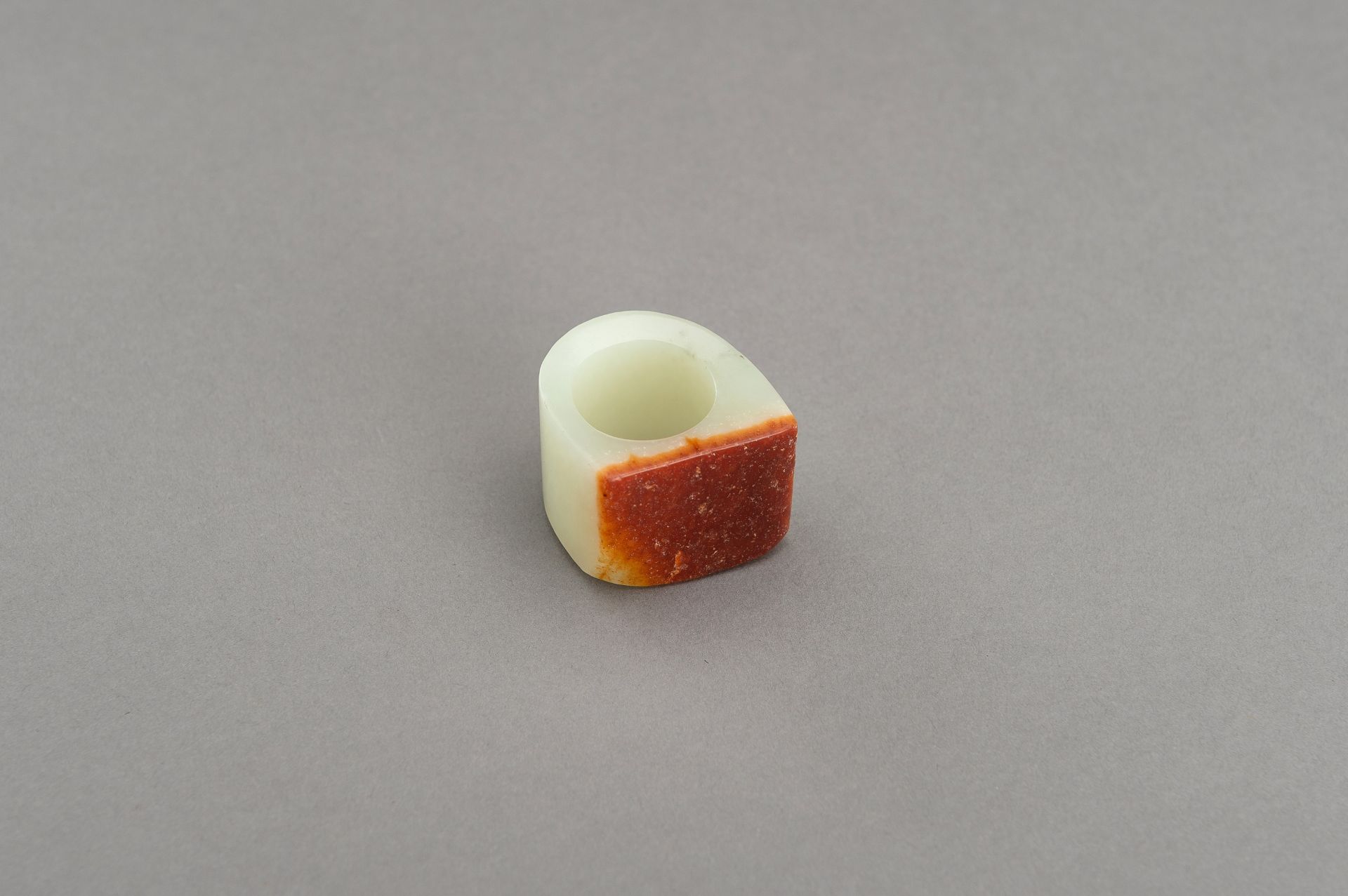A PALE CELADON AND RUSSET JADE ARCHER'S RING - Image 8 of 8