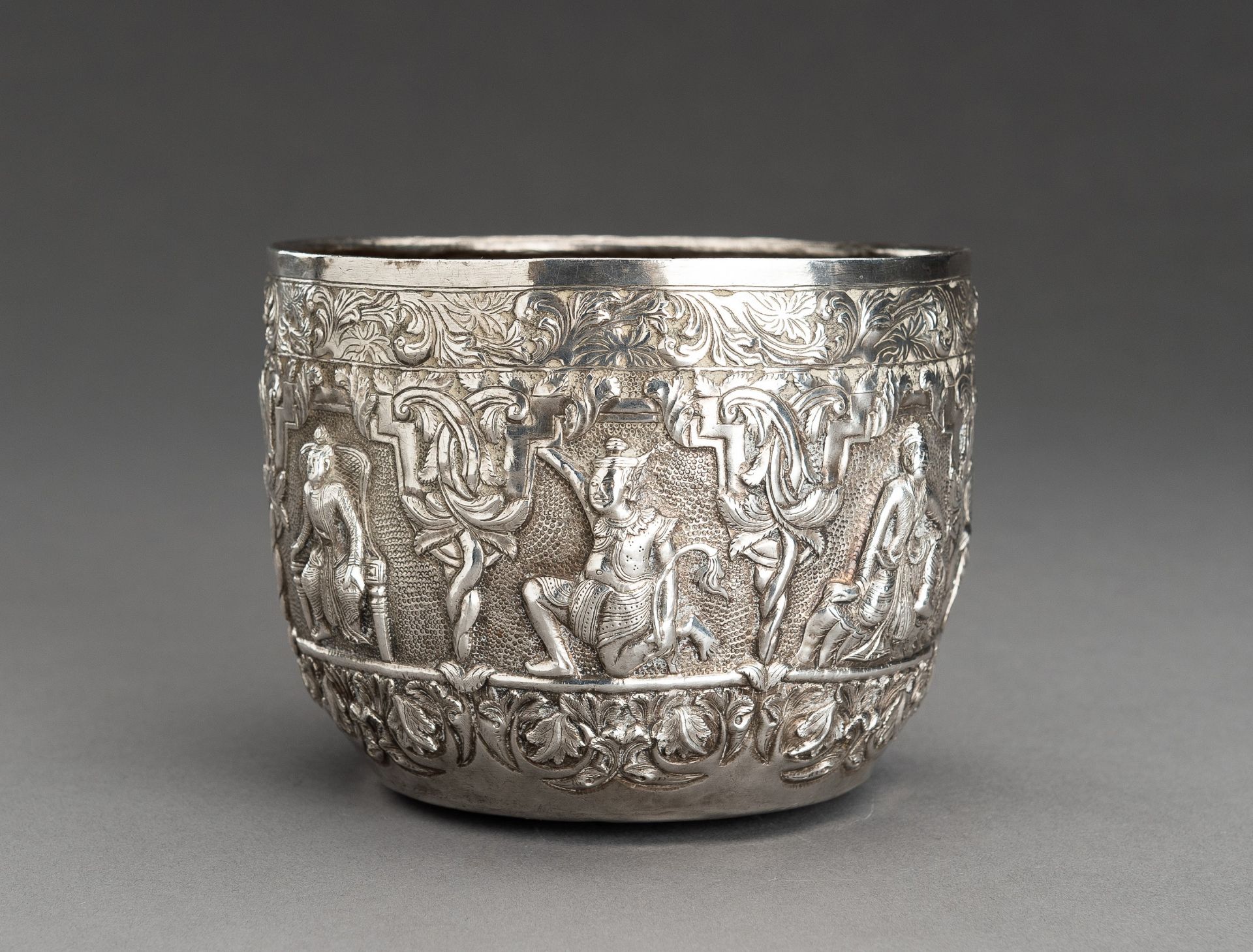 AN EMBOSSED SILVER BOWL WITH FIGURAL RELIEF