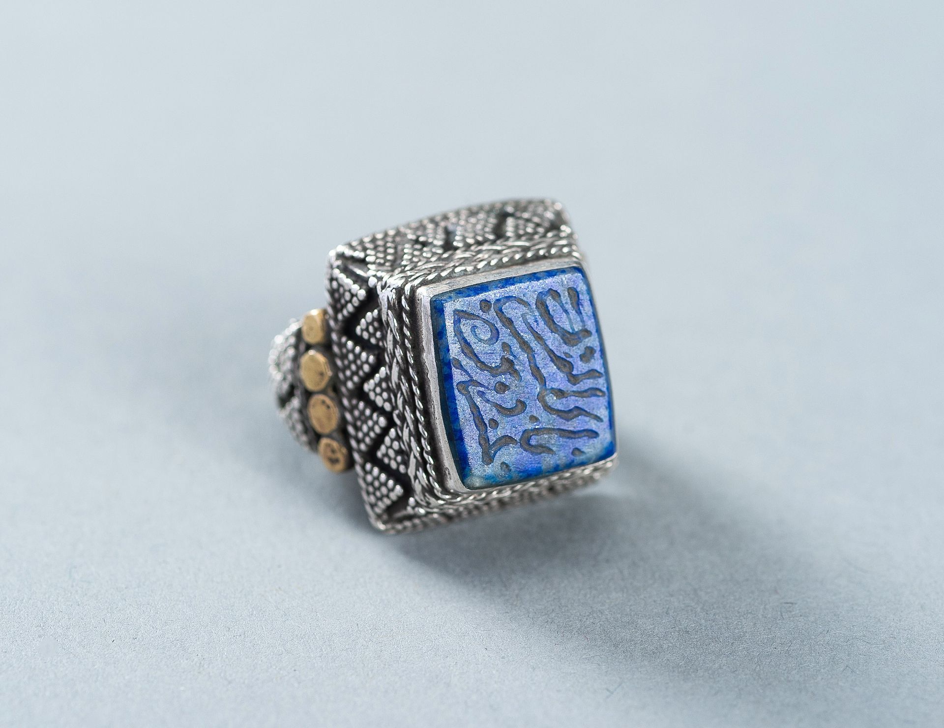 A LAPIS LAZULI INTAGLIO INSET PERSIAN SILVER RING