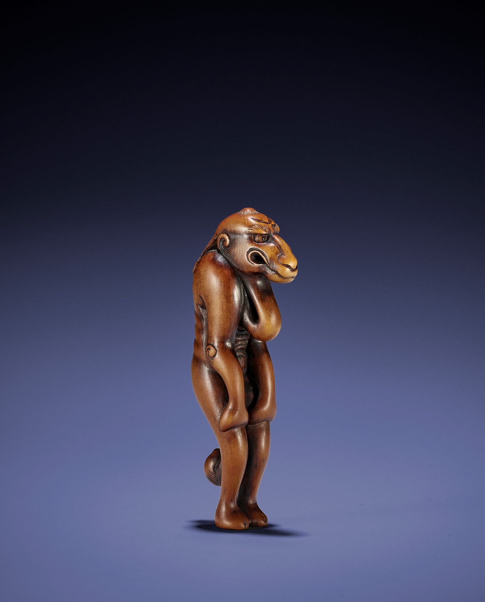 A CONTEMPORARY WOOD NETSUKE OF A MYTHICAL BEAST