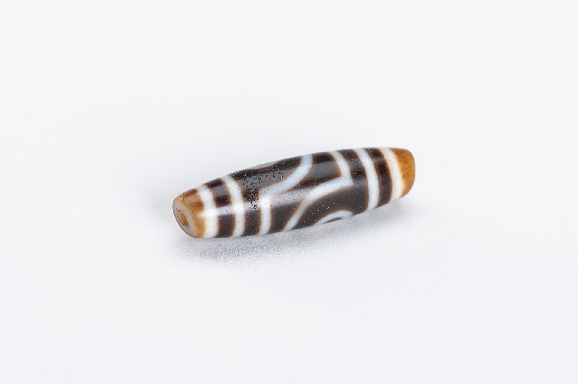 A TIBETAN AGATE 'DZI' BEAD - Image 5 of 7