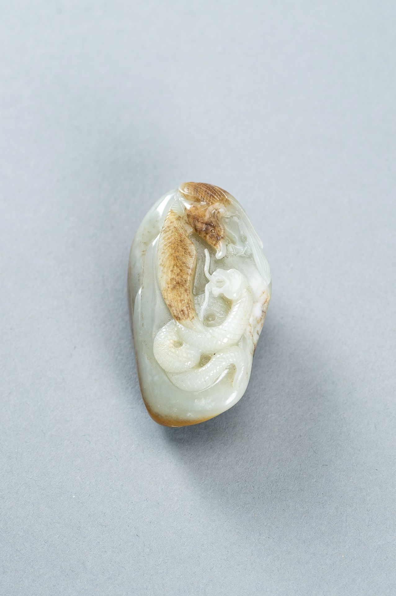 A CELADON AND RUSSET JADE 'EAGLE AND SNAKE' PENDANT, c. 1920s - Image 6 of 9