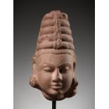 A RED SANDSTONE HEAD OF A DEITY, INDIA, 12TH CENTURY
