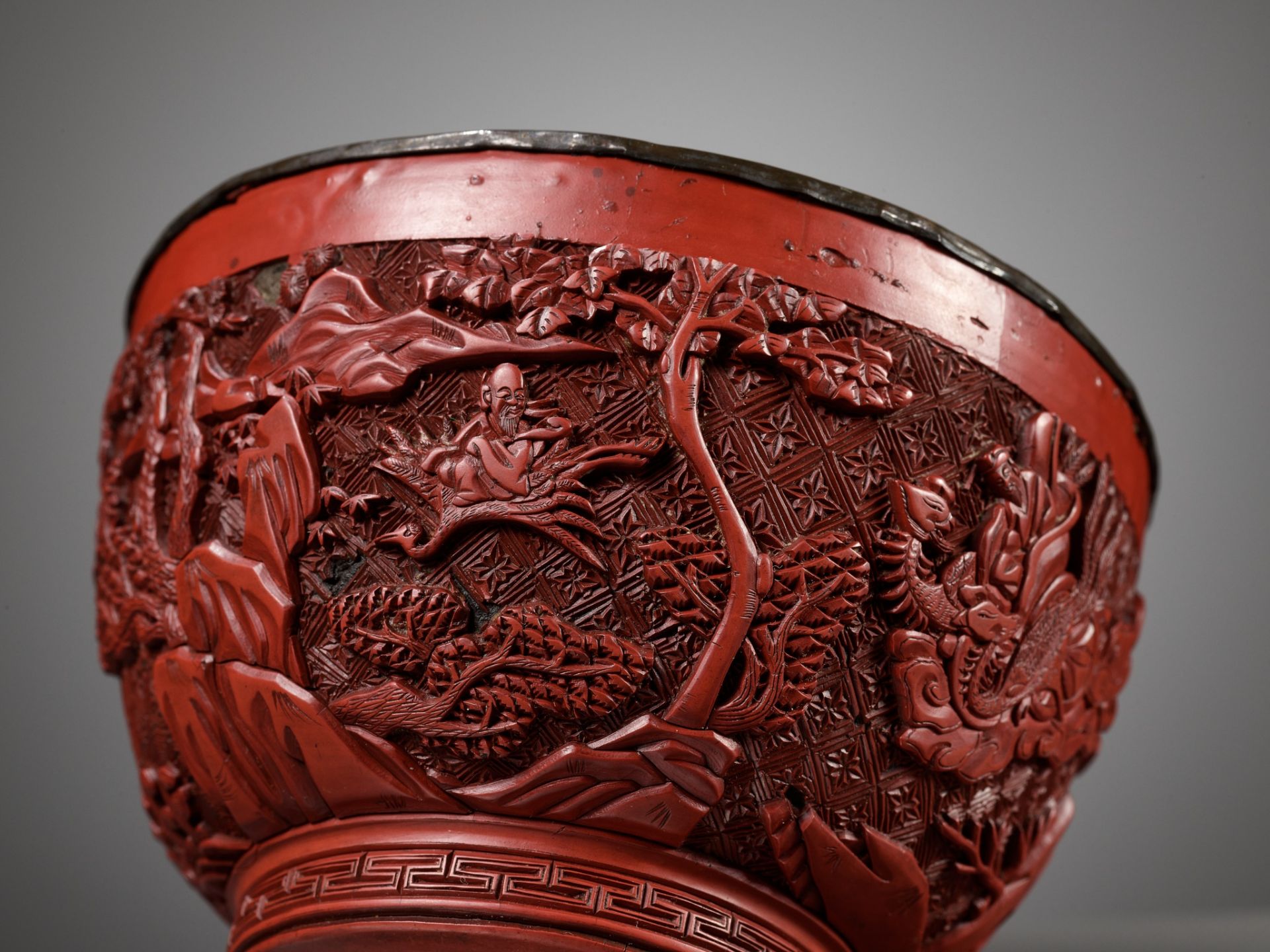 A CINNABAR LACQUER 'IMMORTALS' BOWL, LATE MING DYNASTY