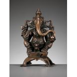 A SILVER-INLAID COPPER ALLOY FIGURE OF GANESHA, SOUTH INDIA, C. 1650-1750
