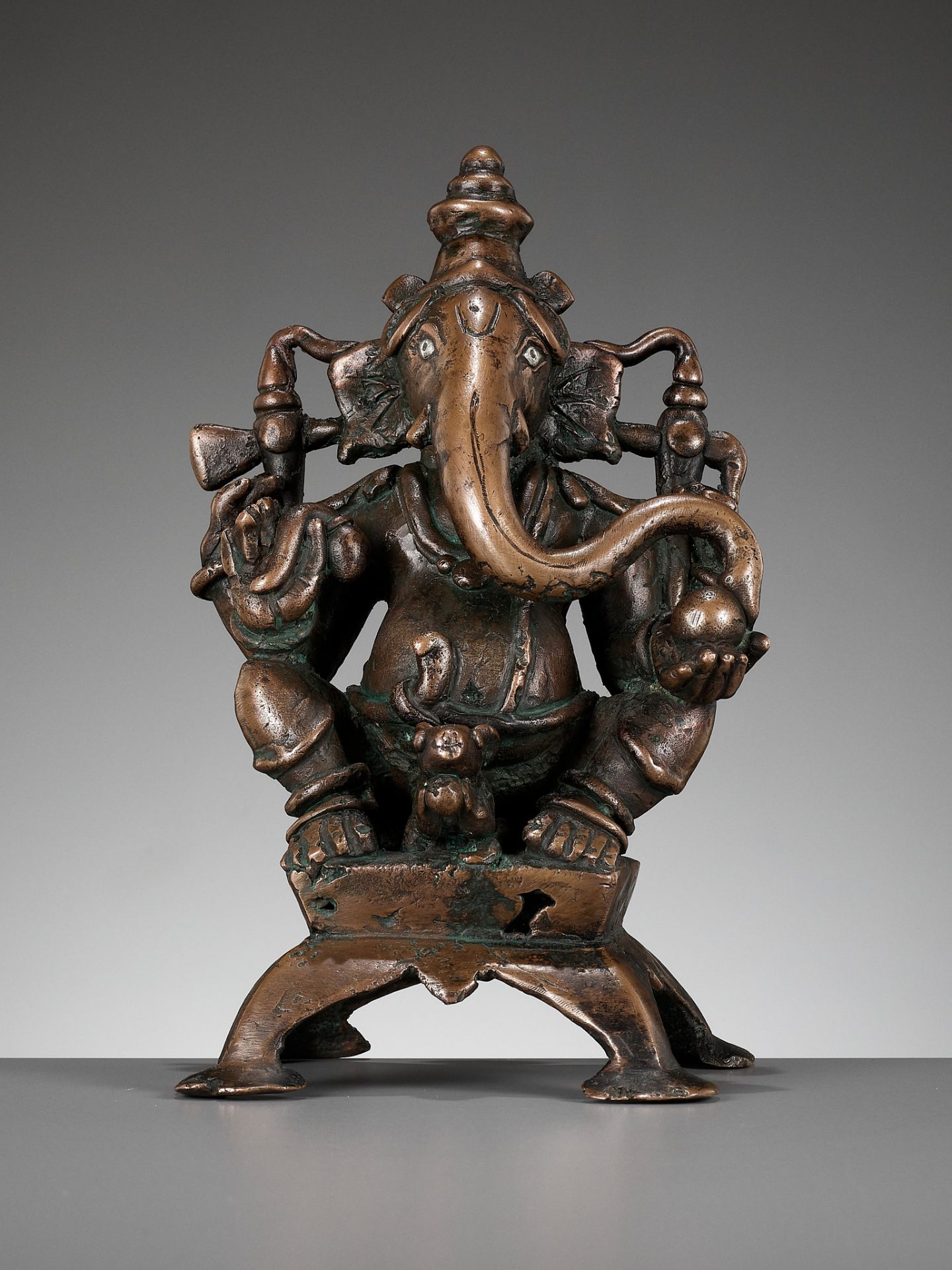A SILVER-INLAID COPPER ALLOY FIGURE OF GANESHA, SOUTH INDIA, C. 1650-1750
