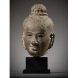 A SANDSTONE HEAD OF AVALOKITESHVARA, ANGKOR PERIOD, BAPHUON STYLE