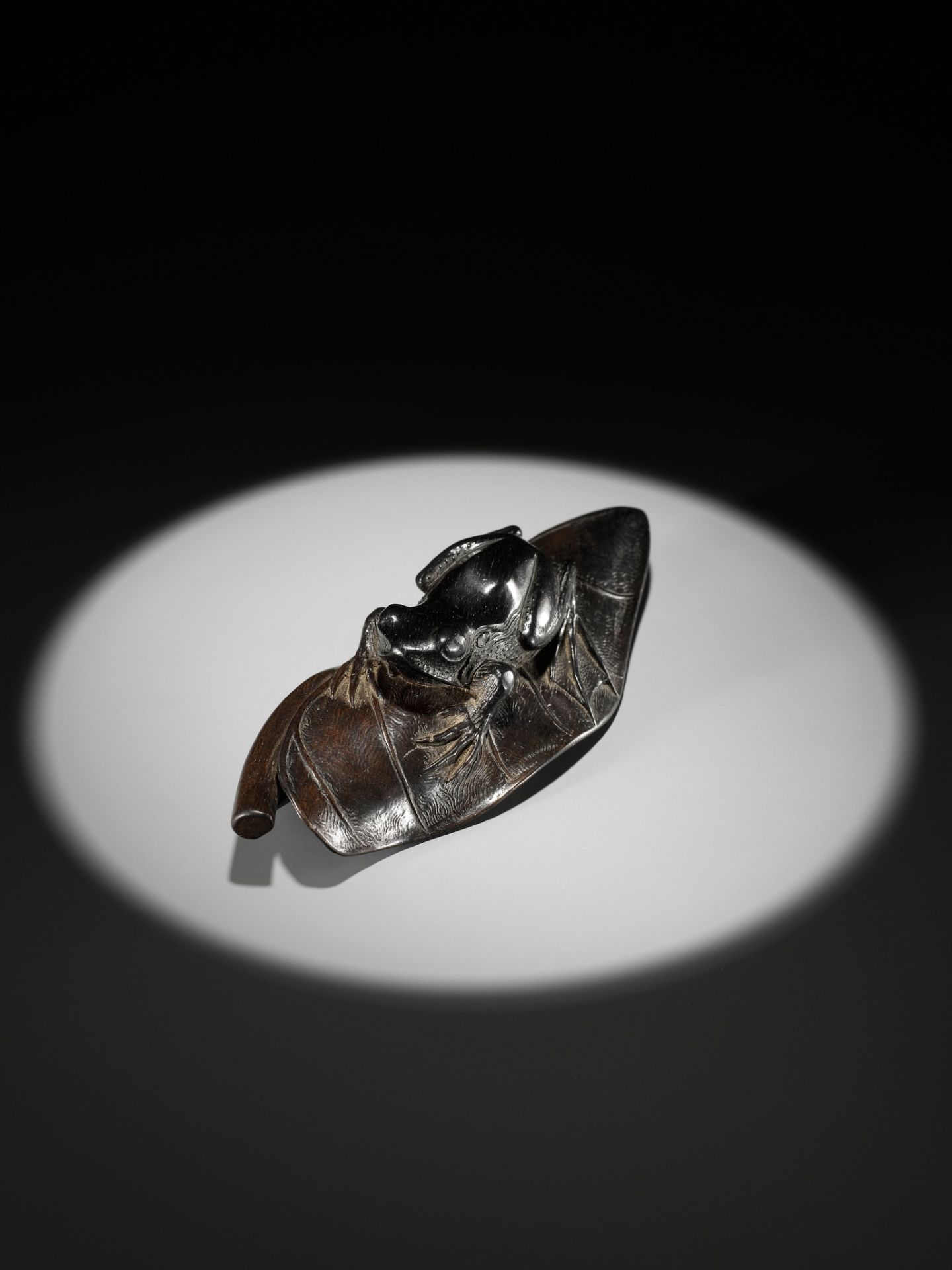 KANMAN: AN EXCEPTIONAL AND LARGE KUROGAKI (BLACK PERSIMMON) WOOD NETSUKE OF A FROG ON A LOTUS LEAF - Image 17 of 20