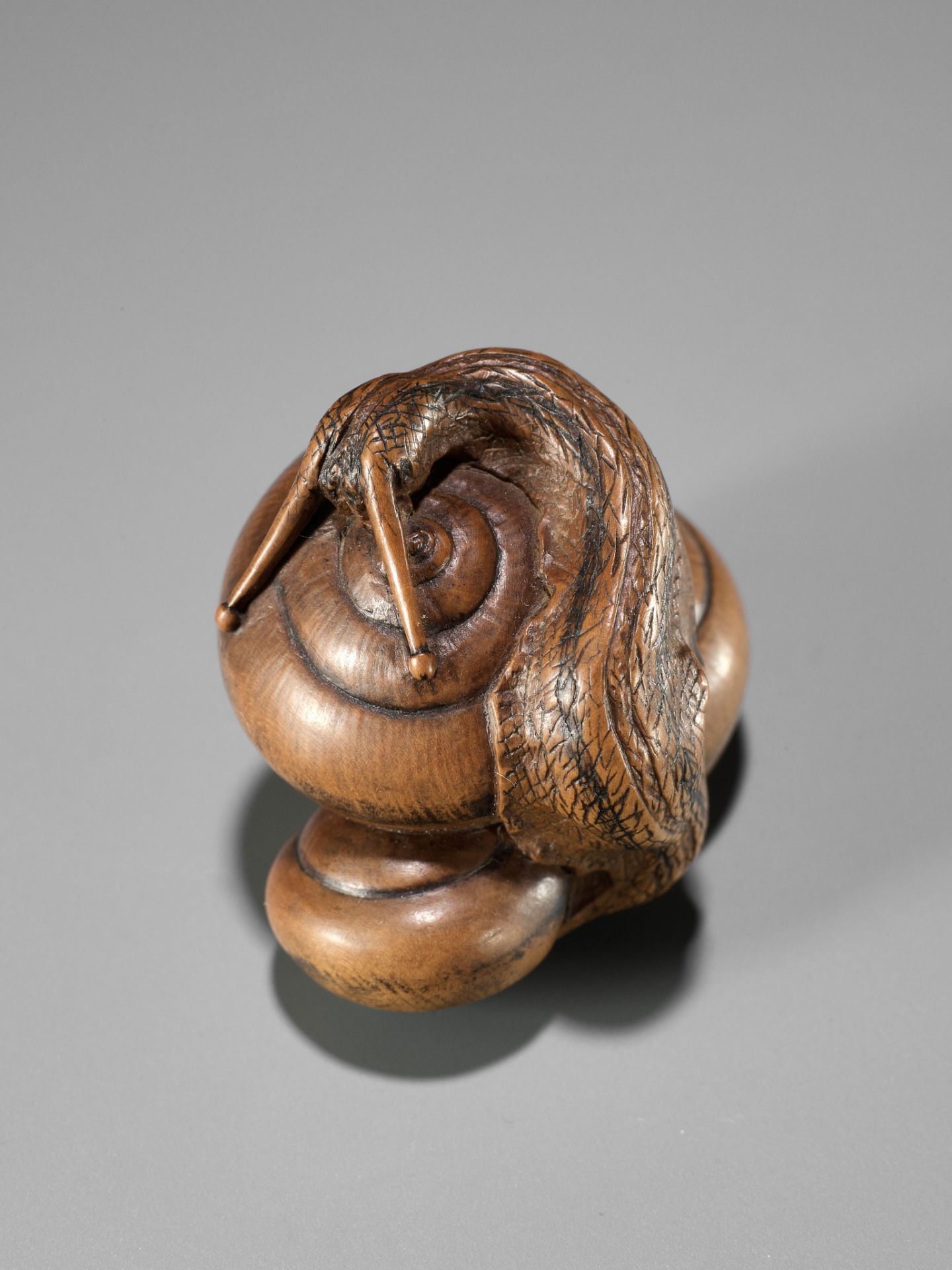 HIDEHARU: A SUPERB WOOD NETSUKE OF THREE SNAILS