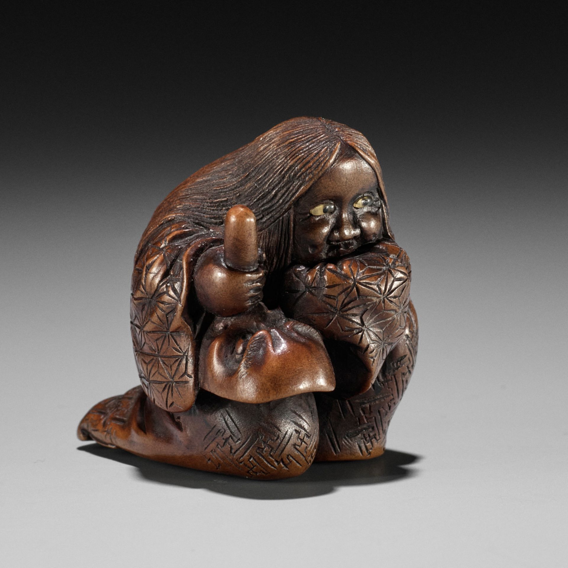 NOBUKAZU: A WOOD SHUNGA NETSUKE OF OKAME WITH TENGU MASK