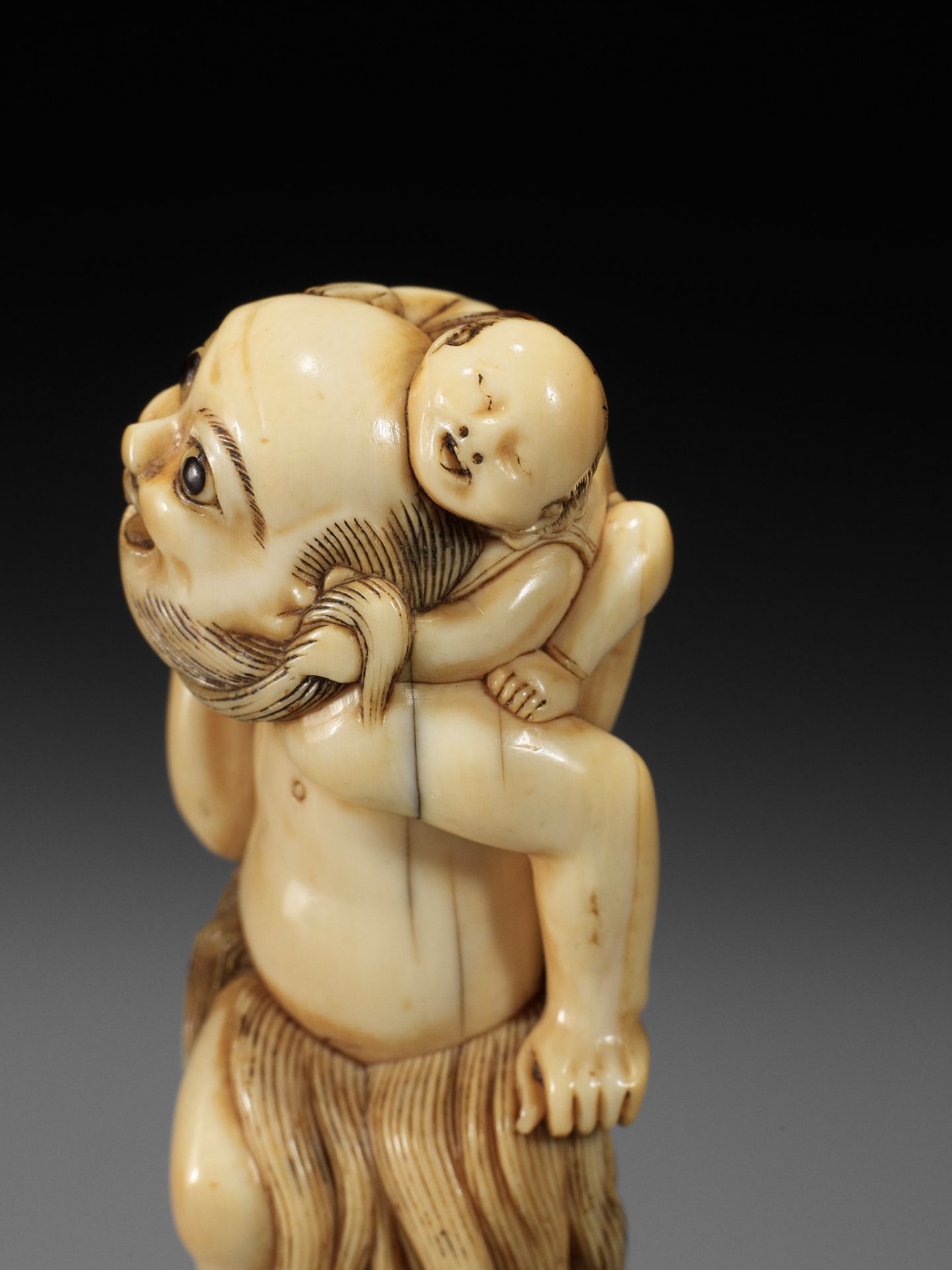 A SUPERB IVORY NETSUKE OF A FISHERMAN CARRYING A BOY, ATTRIBUTED TO GECHU - Image 6 of 12