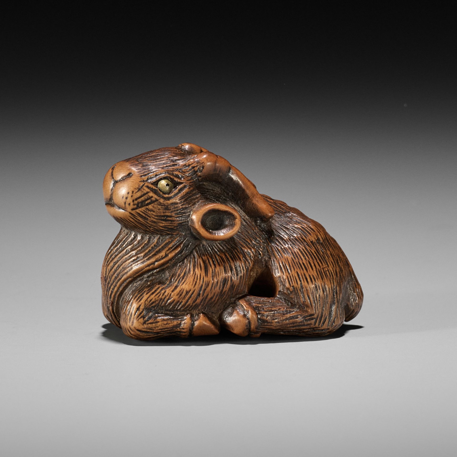 MINKO: A WOOD NETSUKE OF A RECUMBENT GOAT