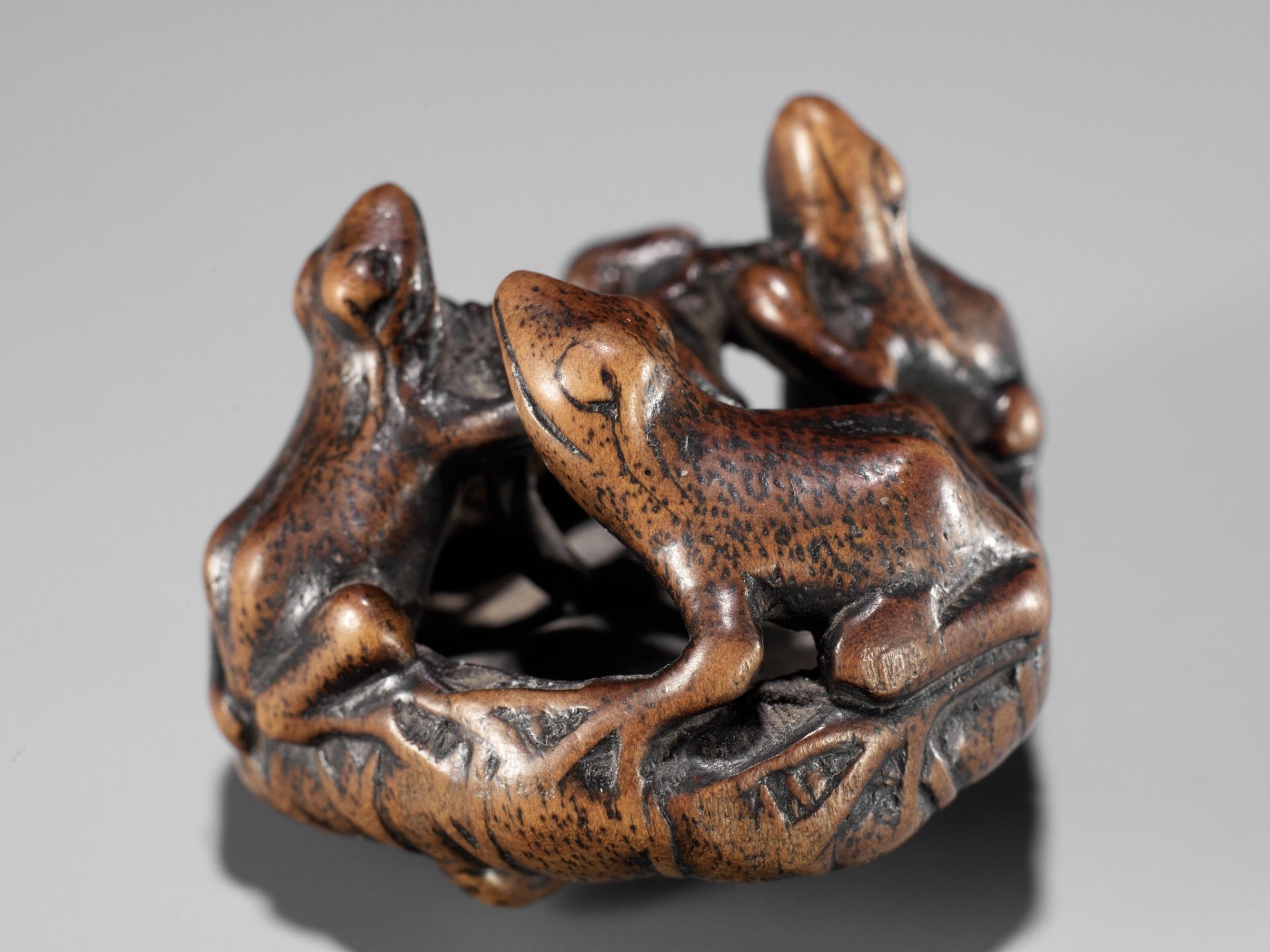 SEIMIN: A FINE WOOD NETSUKE OF A FROGS ON A LOTUS LEAF