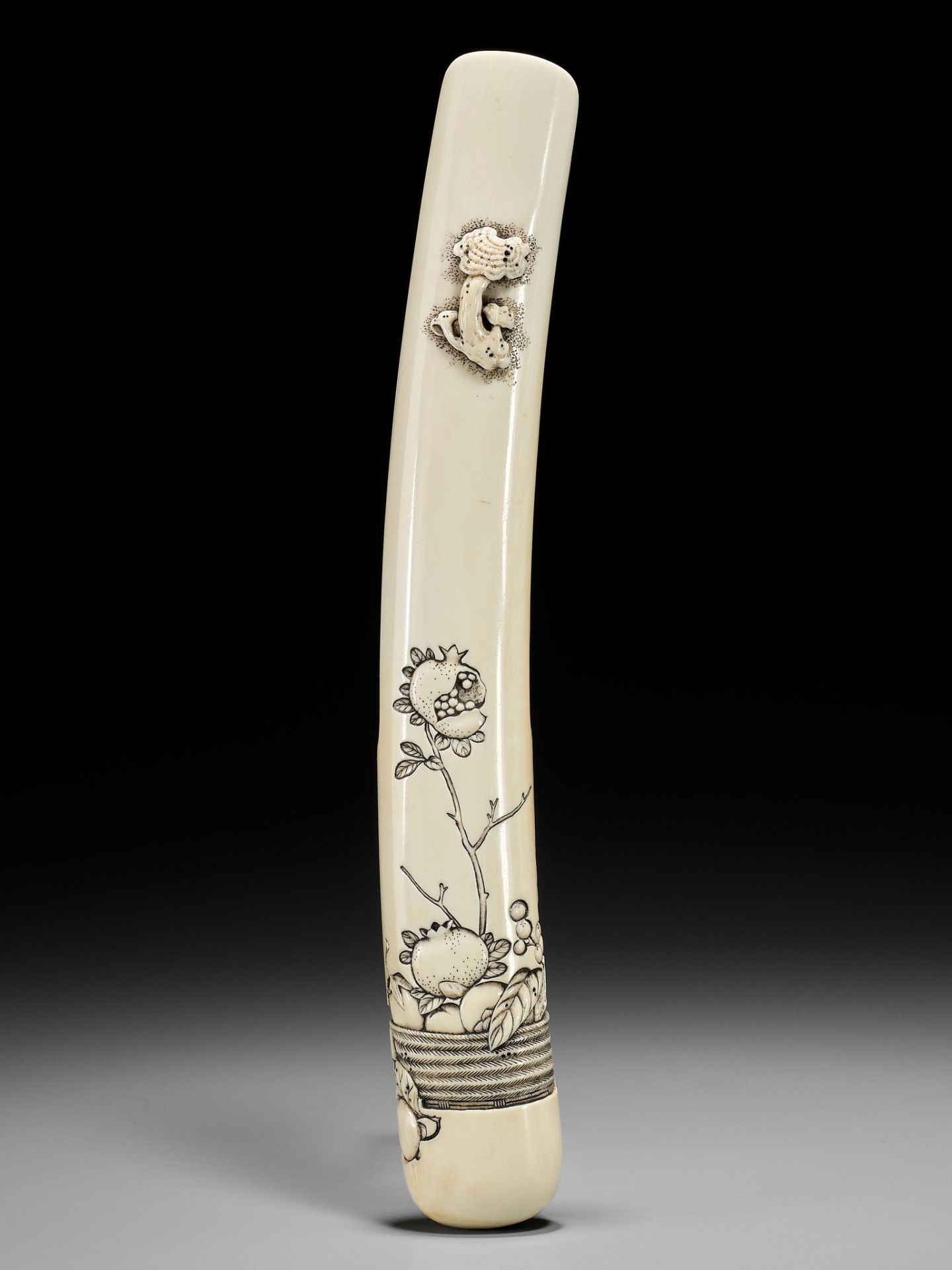 RENSAI: A RARE MARINE IVORY KISERUZUTSU WITH A BASKET OF FRUIT