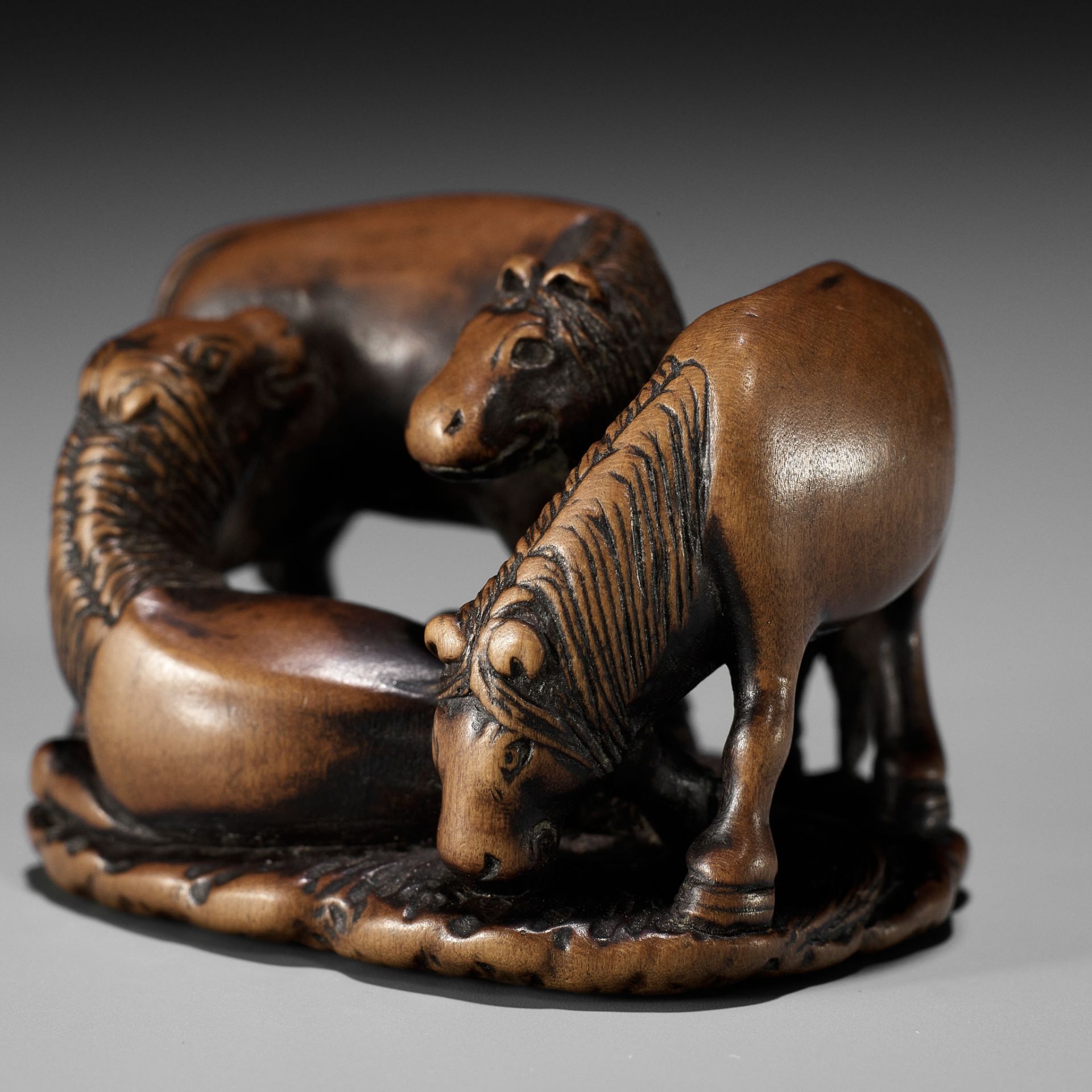 ISSAI: A CHARMING WOOD NETSUKE OF THREE HORSES