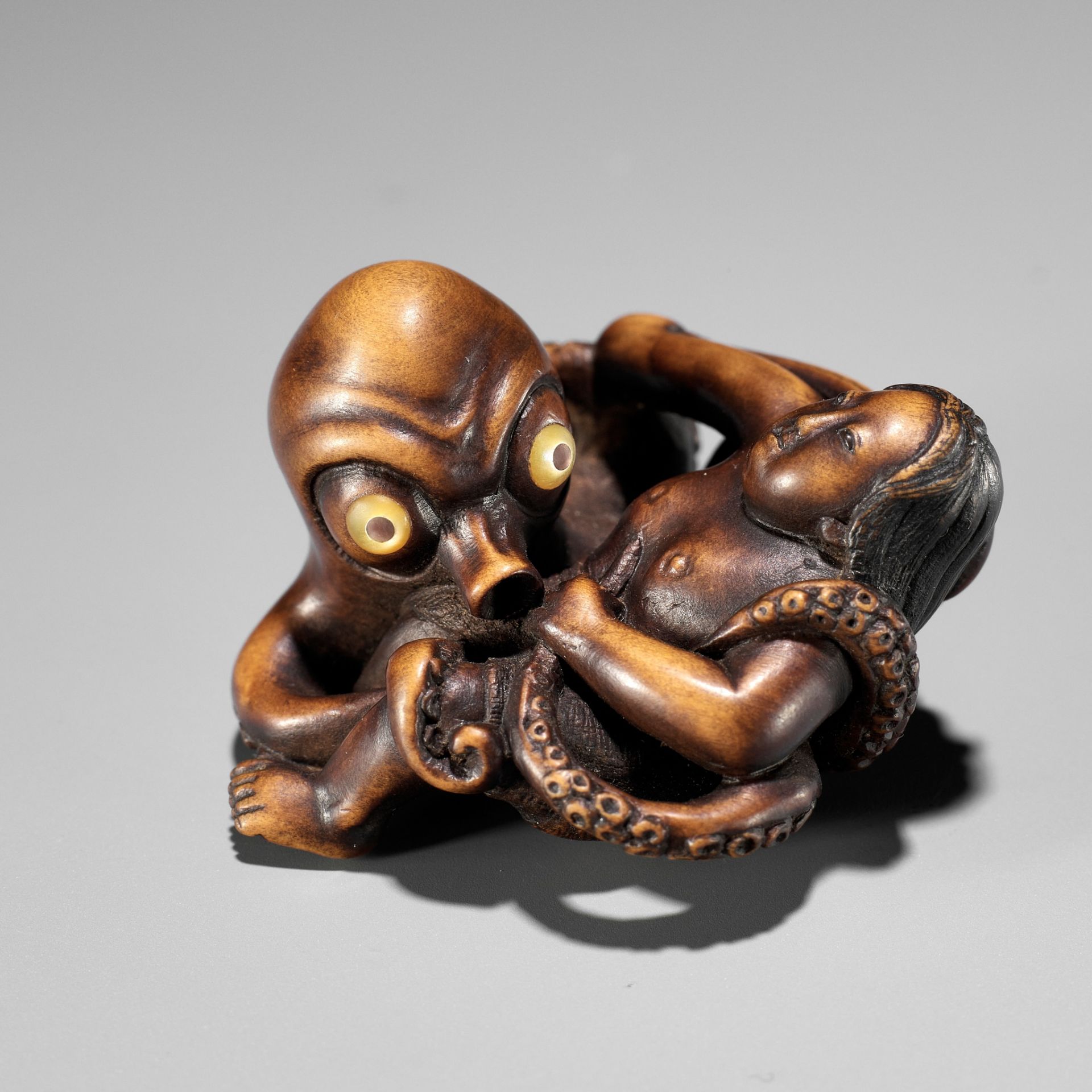 A SUPERB WOOD NETSUKE OF AN AMA STRUGGLING WITH AN OCTOPUS, ATTRIBUTED TO IKKYU