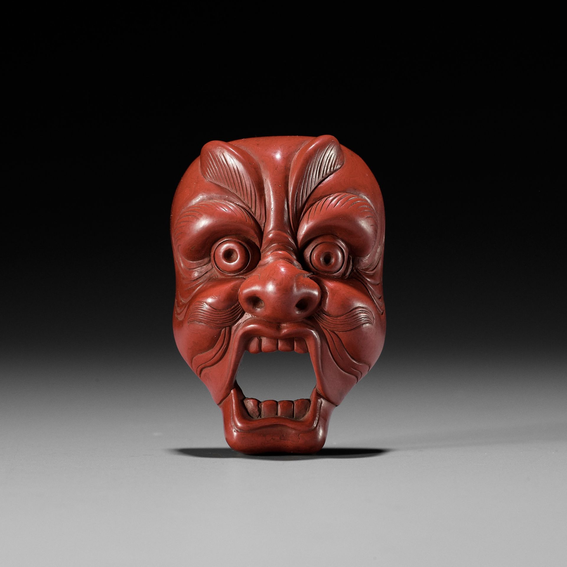 JOKO: A RARE TSUISHU (RED LACQUER) BUGAKU MASK NETSUKE OF GENJORAKU