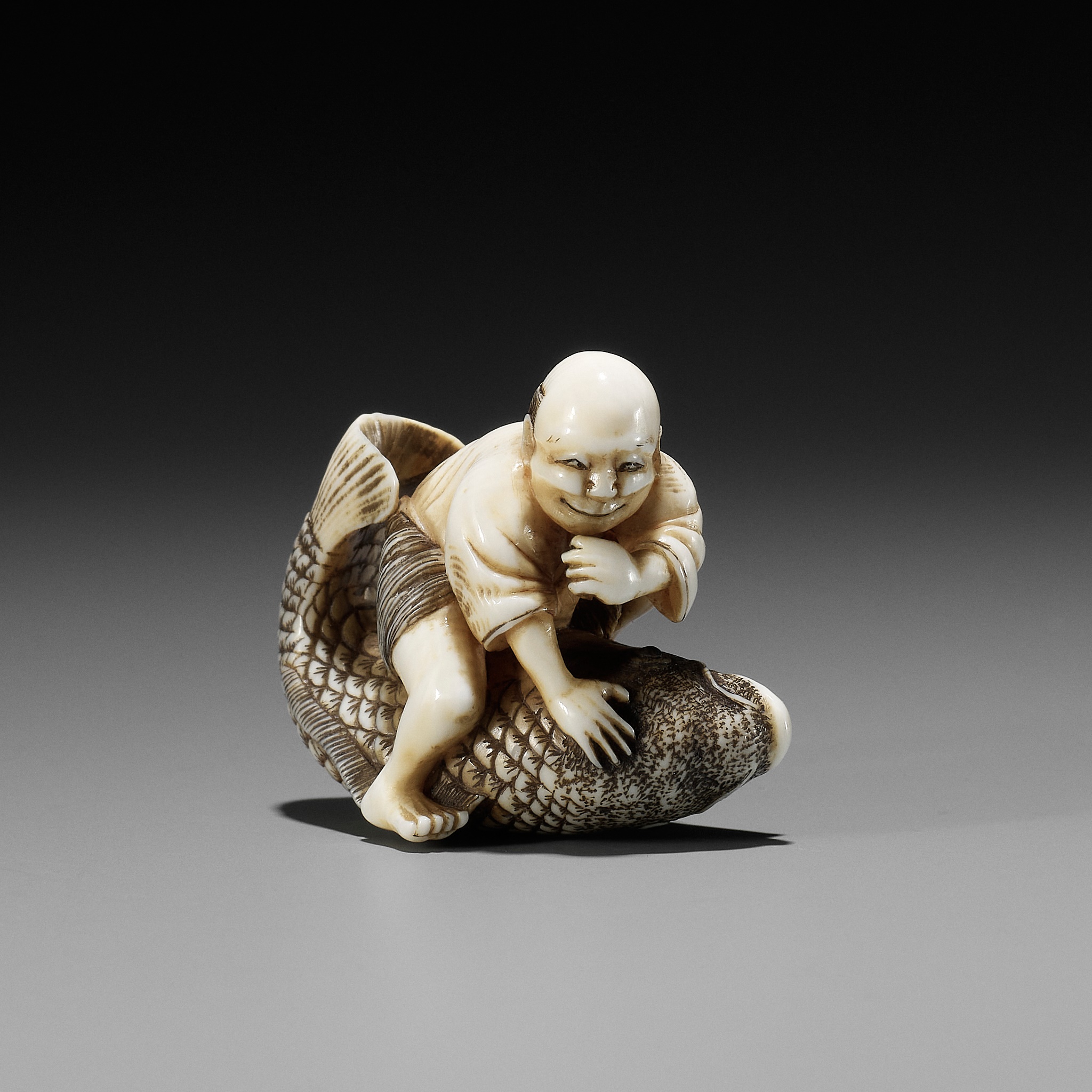 MASAMINE: A FINE OSAKA SCHOOL IVORY NETSUKE OF A FISHERMAN STRUGGLING WITH A HUGE CARP