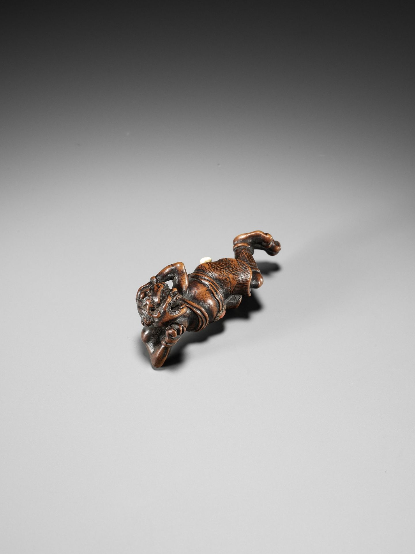 AN INLAID WOOD NETSUKE OF A RECLINING ONI AT SETSUBUN - Image 8 of 10