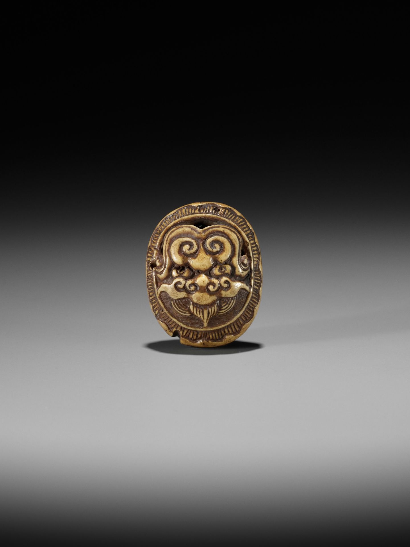 KOKUSAI: A STAG ANTLER RYUSA MANJU NETSUKE DEPICTING A ROOF TILE WITH ONI MASK (ONIGAWARA) - Image 3 of 14