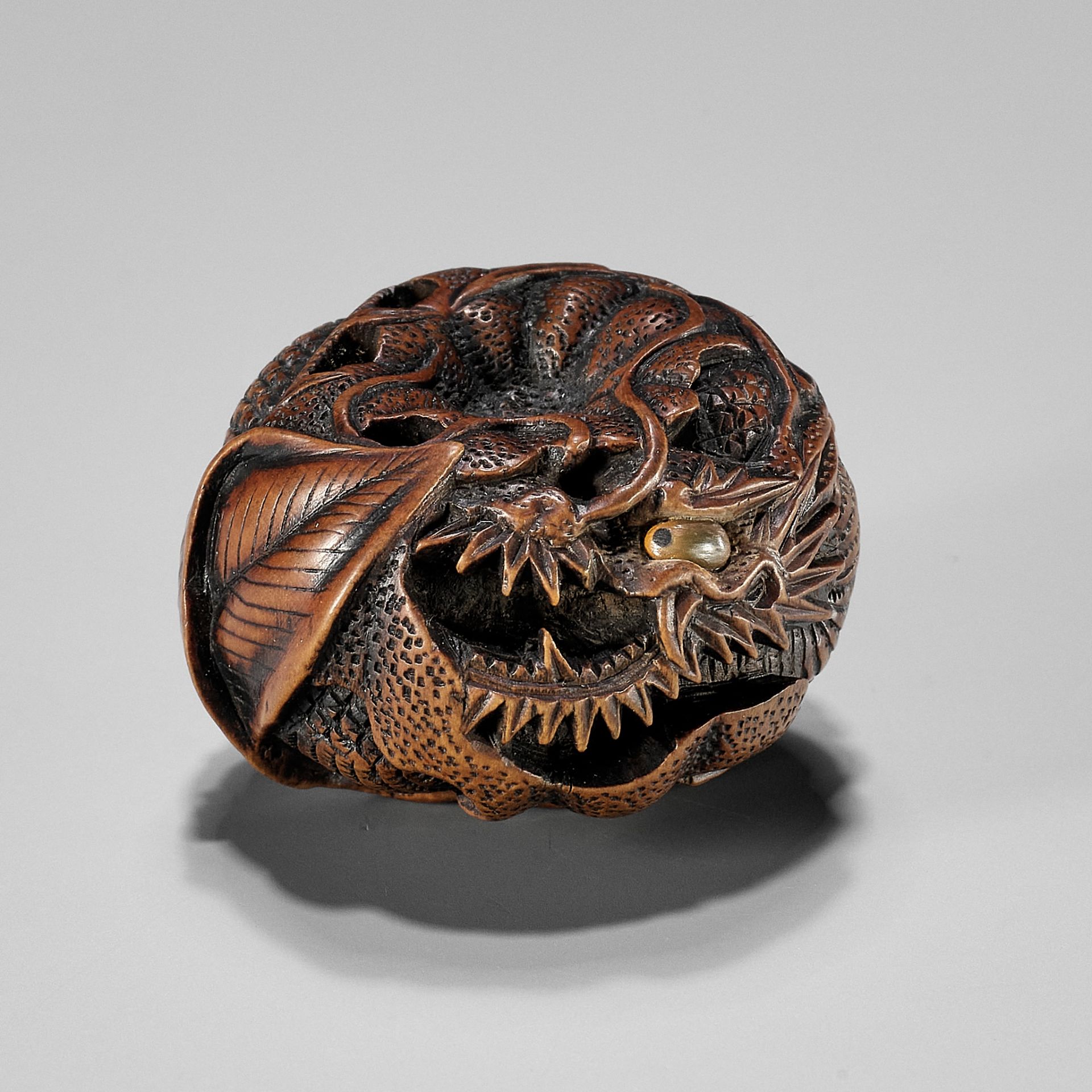 TOYOMASA: A FINE WOOD NETSUKE OF A DRAGON IN A MIKAN