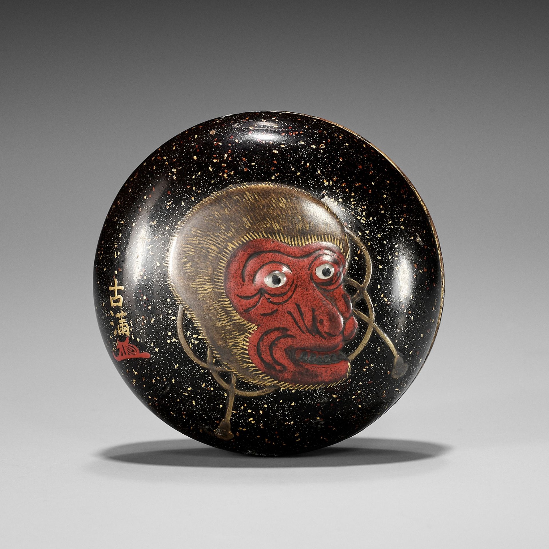 KOMA: A LARGE LACQUER MANJU NETSUKE WITH SARU MASK