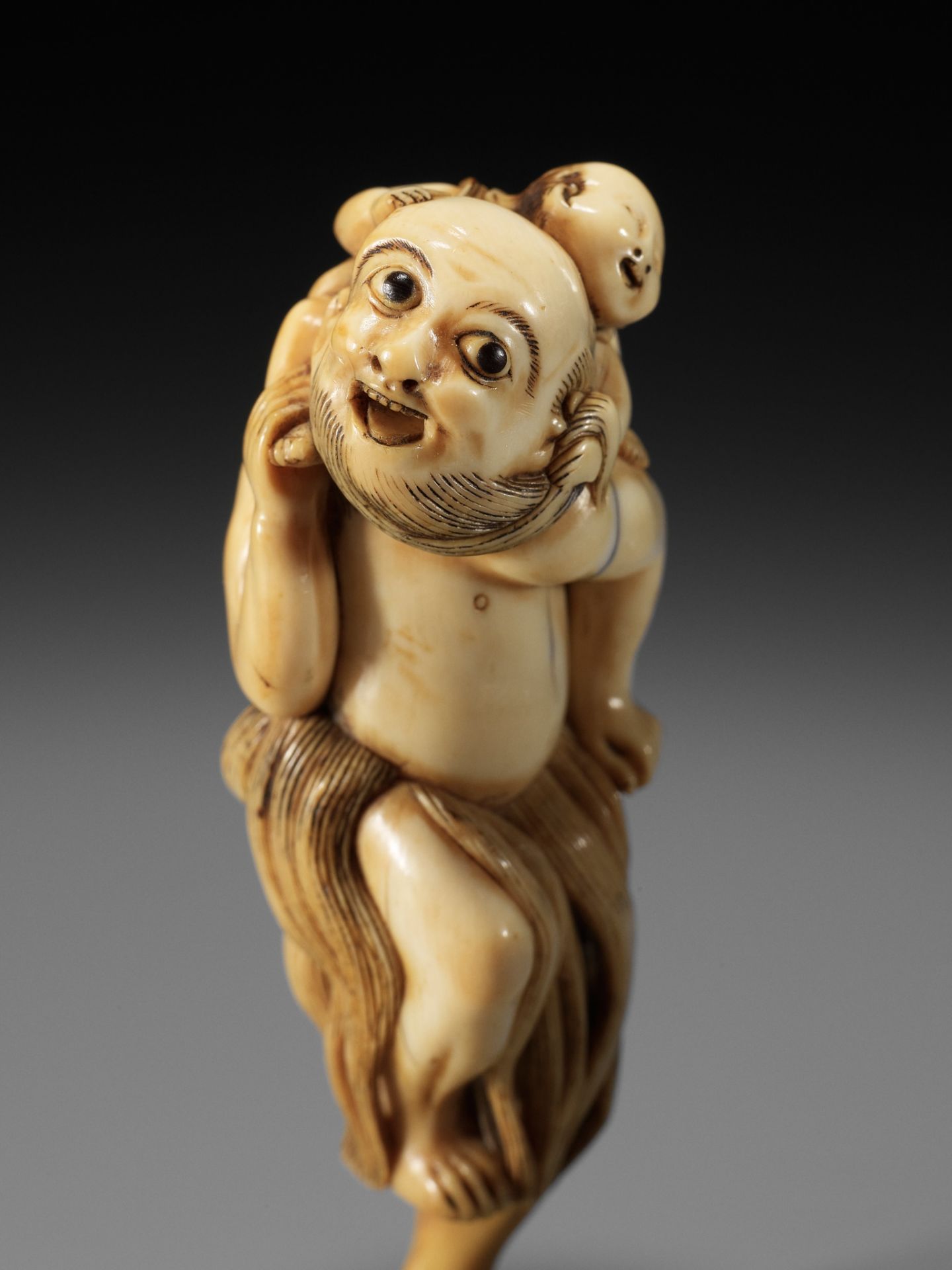 A SUPERB IVORY NETSUKE OF A FISHERMAN CARRYING A BOY, ATTRIBUTED TO GECHU - Image 4 of 12