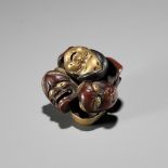 A LACQUER NETSUKE OF A CLUSTER OF MASKS